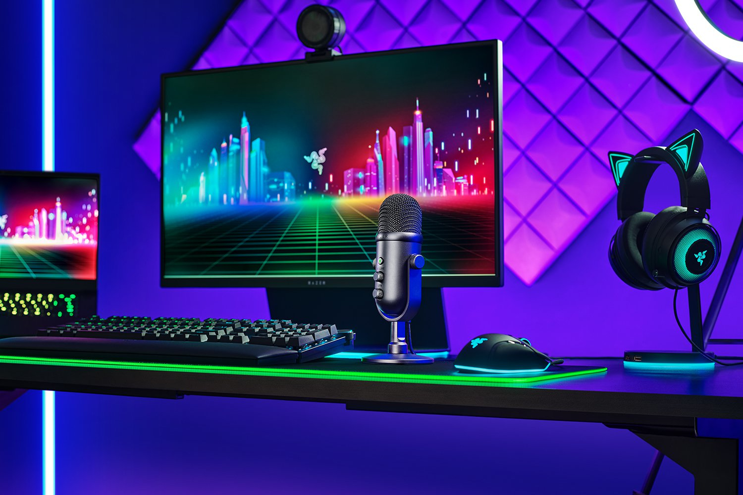Een gaming-opstelling met een monitor, toetsenbord, muis en koptelefoon. Paarse en blauwe verlichting.