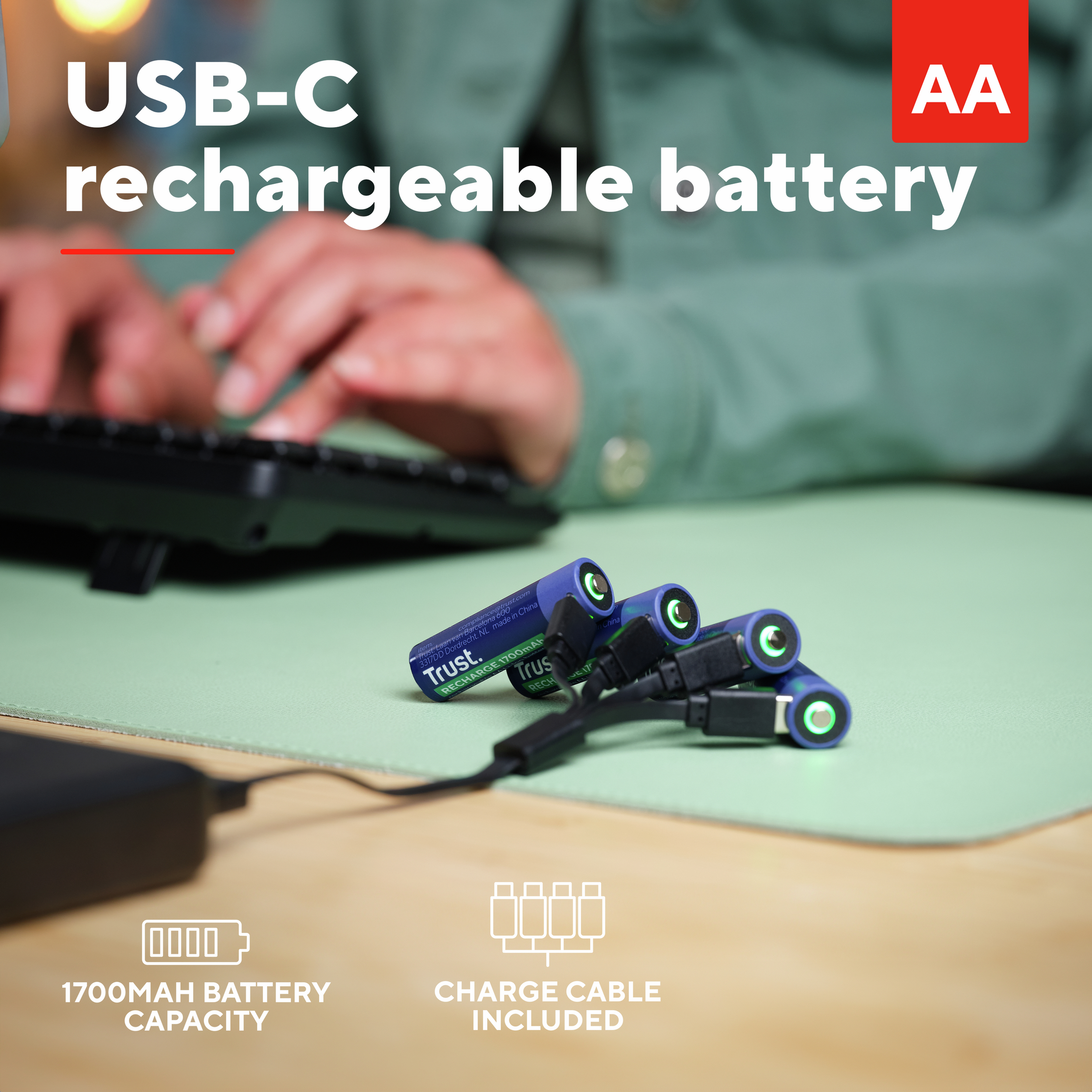 Mani che digitano su una tastiera con batterie, cavi di ricarica e icona batteria con testo.
