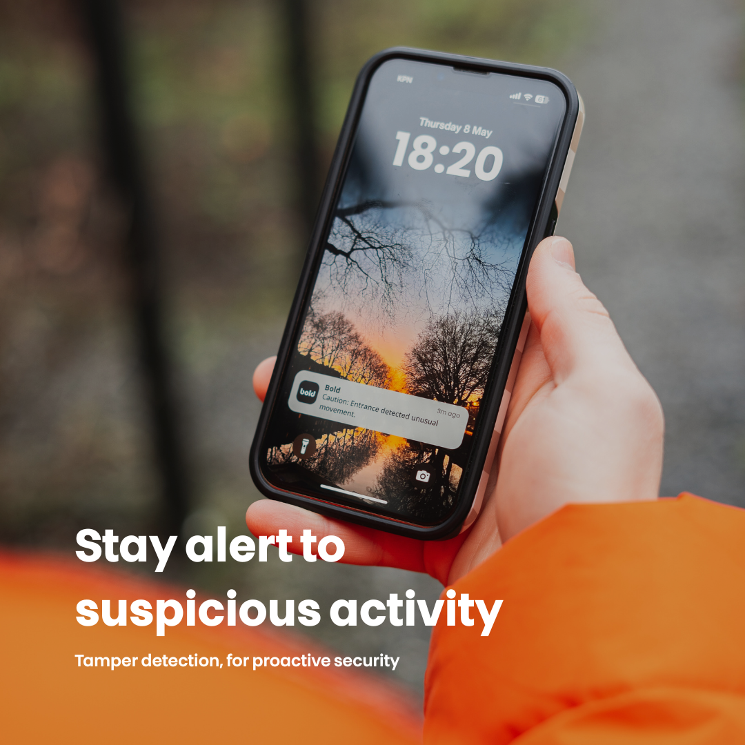 Main tenant un smartphone affichant une alerte de sécurité, fond flou.