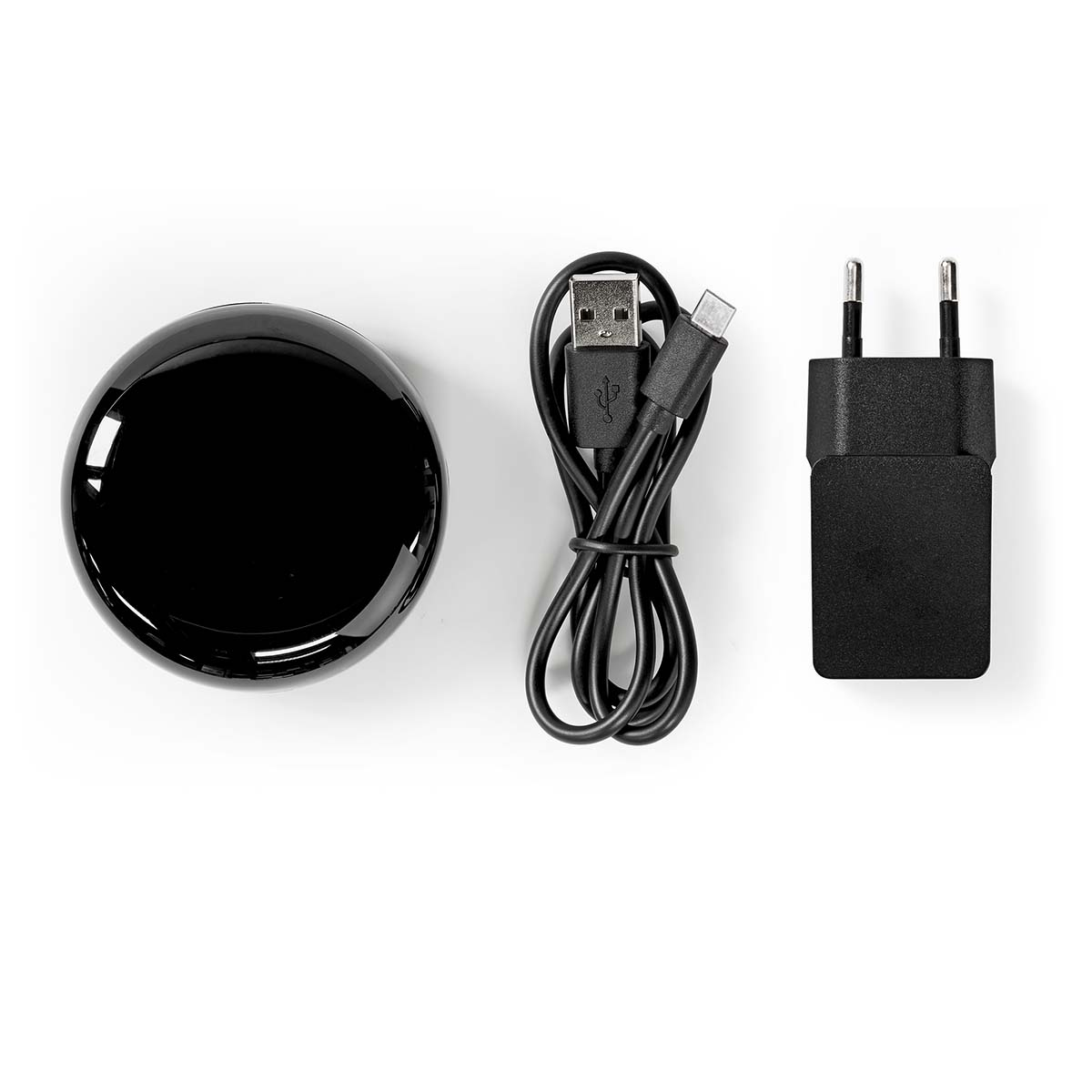 Un dispositivo domestico intelligente nero e rotondo, con un cavo USB e un adattatore di alimentazione.