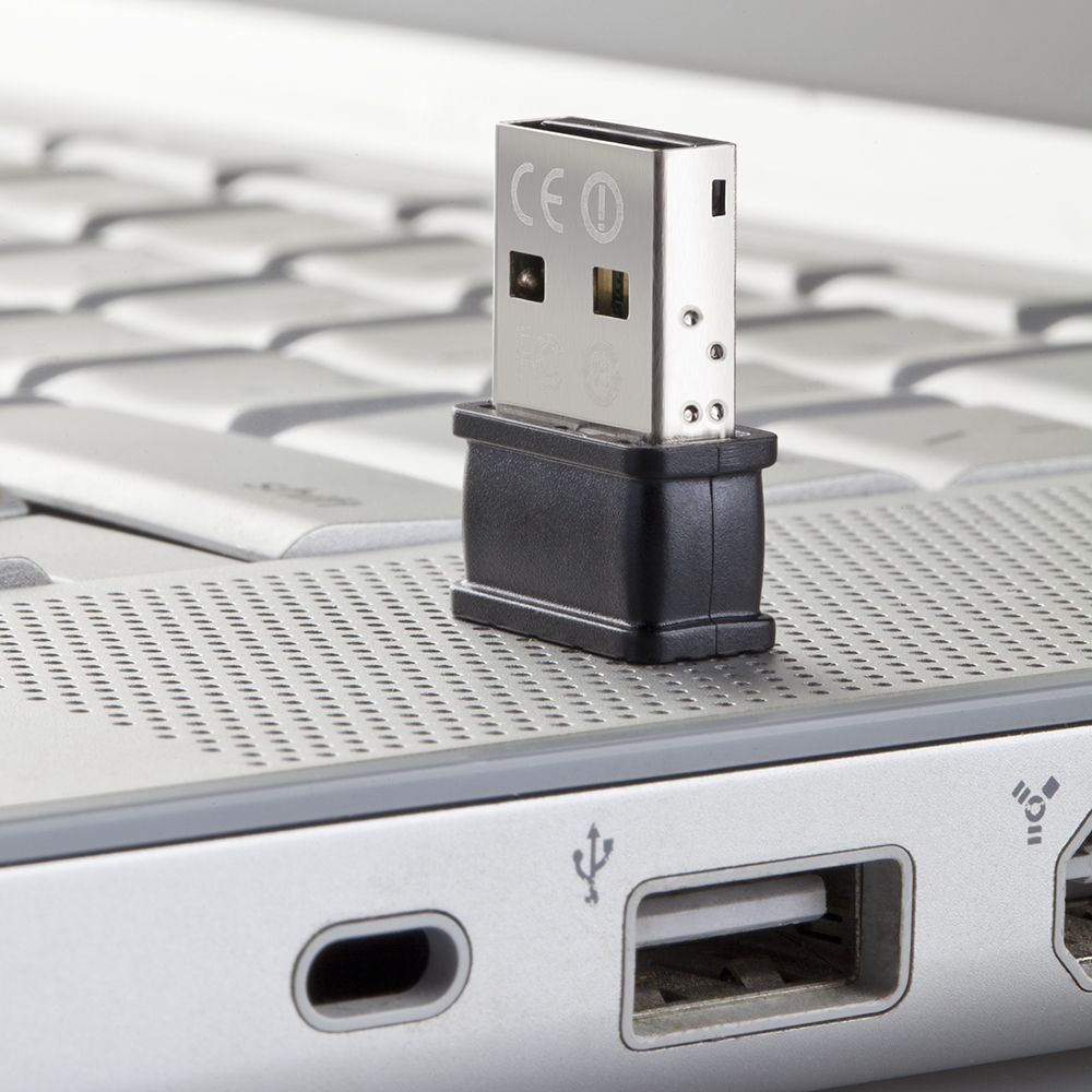 Pamięć flash USB podłączona do laptopa. Dysk jest srebrny i czarny, podłączony do portu USB.