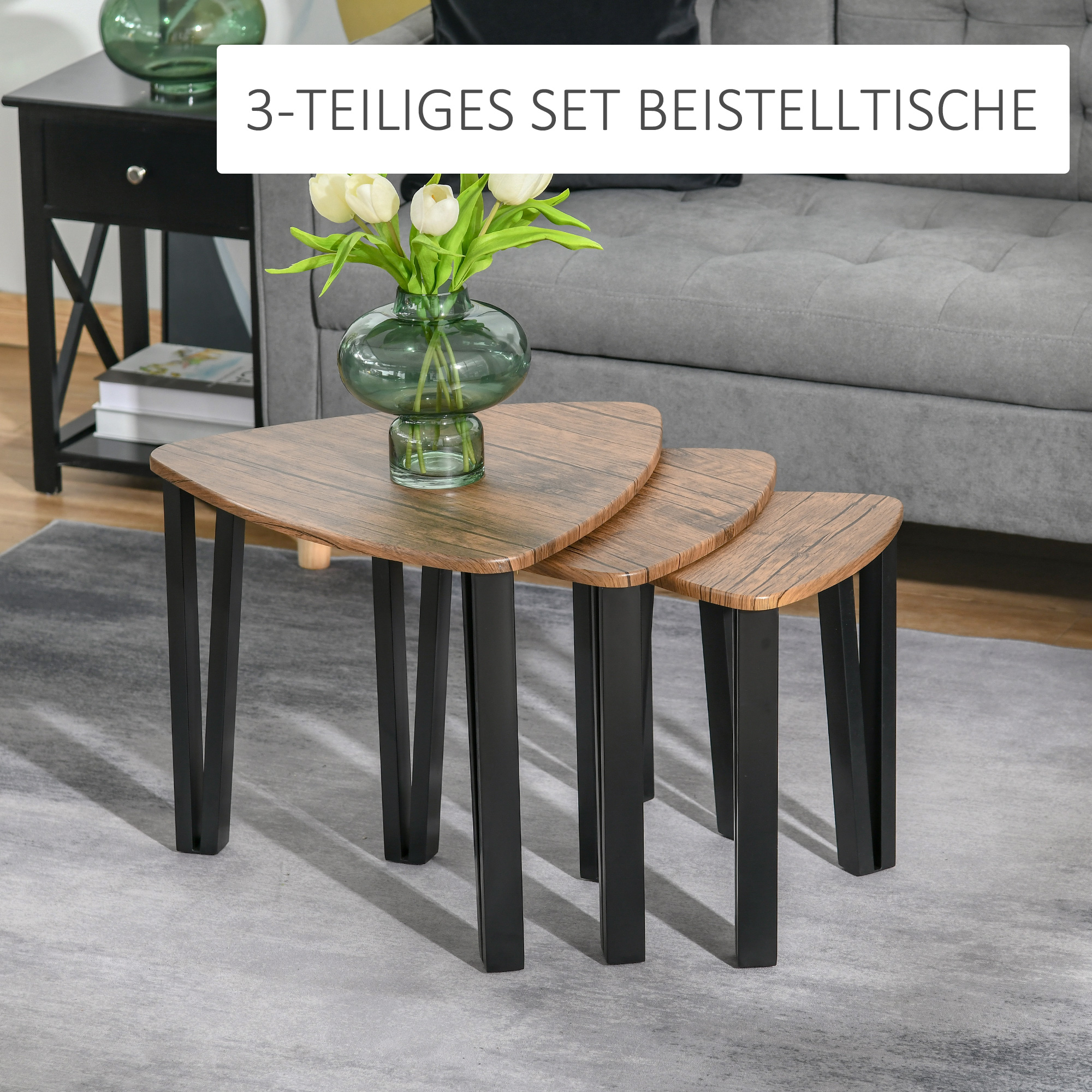 Drei Holztische mit schwarzen Beinen. Eine Vase mit Blumen auf dem Mitteltisch.