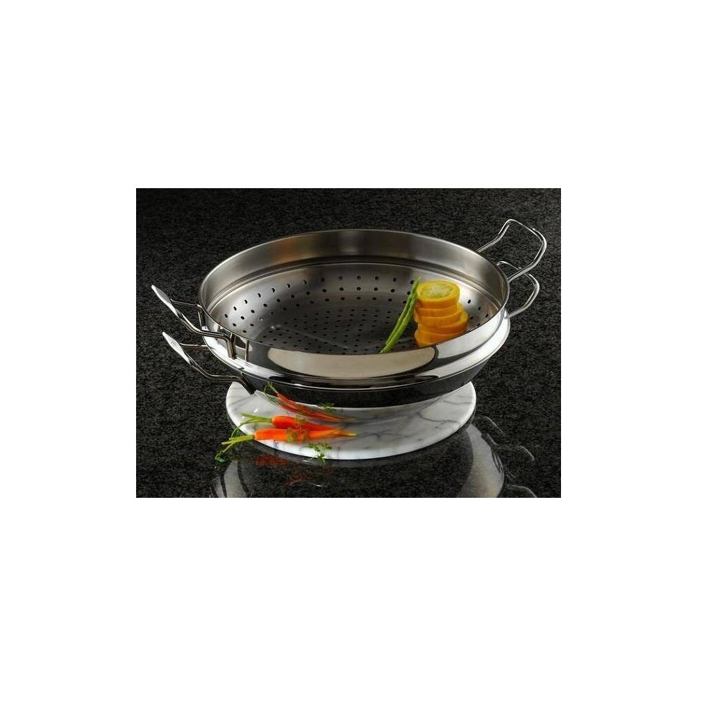 Una vaporiera in acciaio inox con verdure su un piatto di marmo. Carote e fette di limone sono visibili.