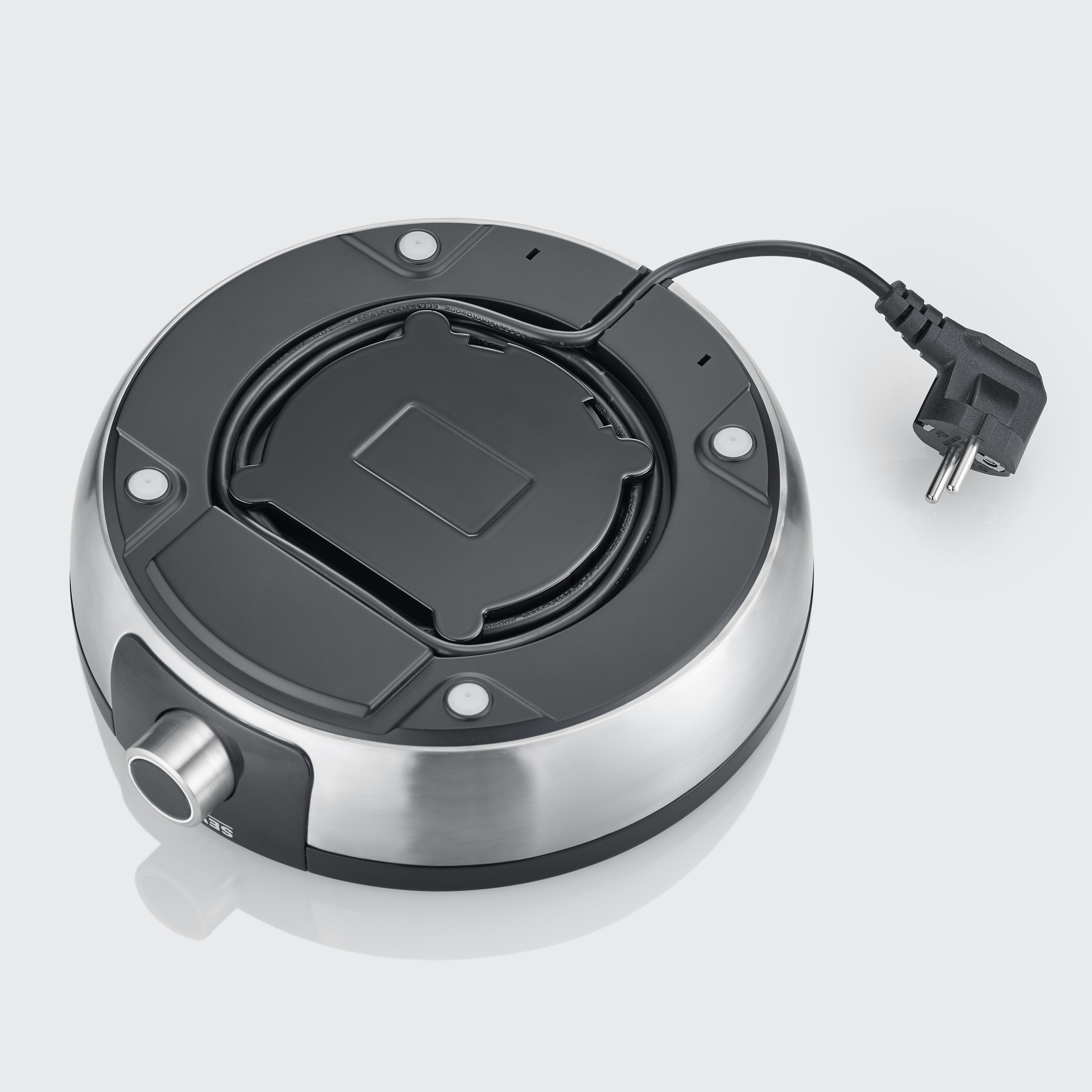 Parte inferior de una tetera plateada con base negra y cable de alimentación.