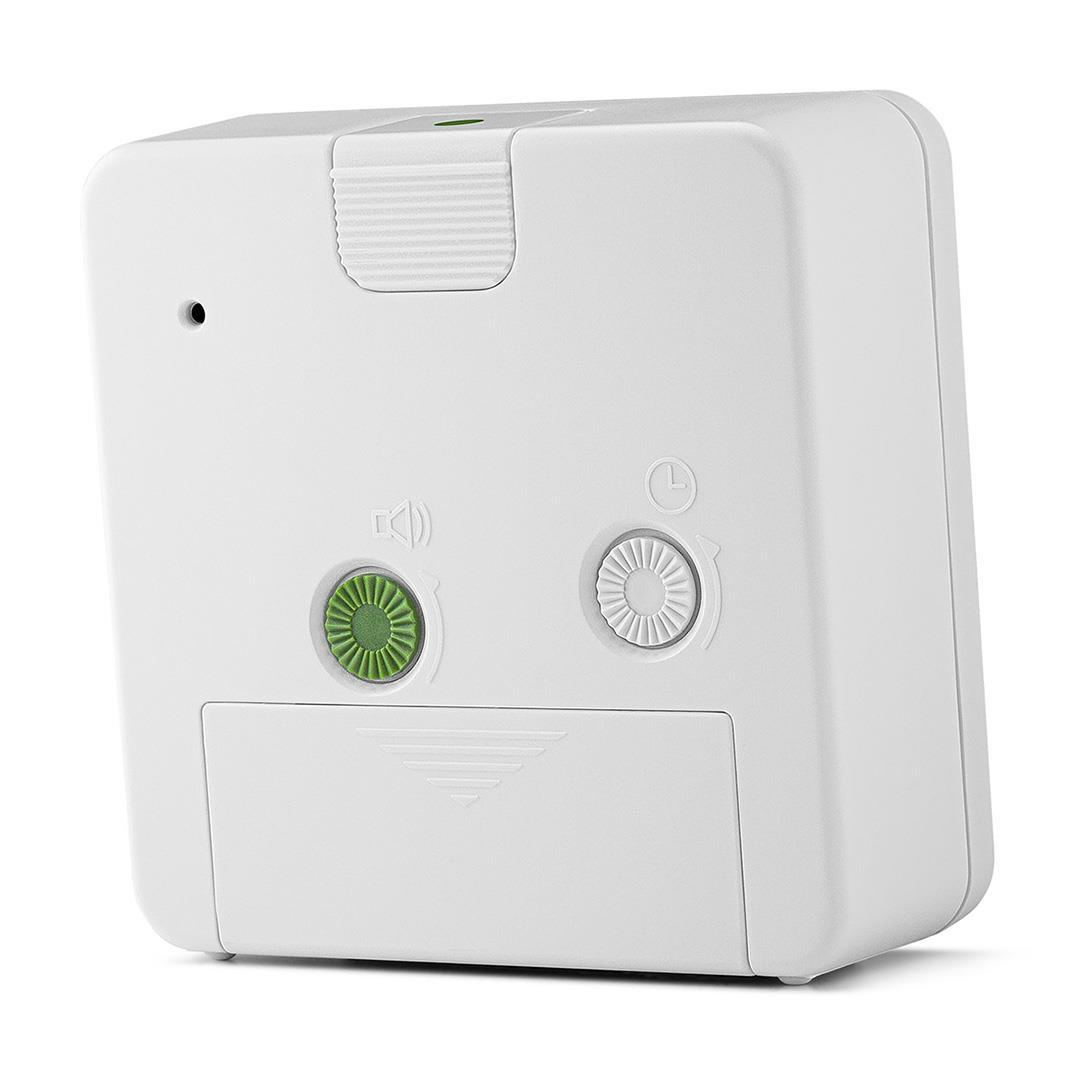 Tył białego kwadratowego budzika z przyciskami i drzwiczkami baterii.