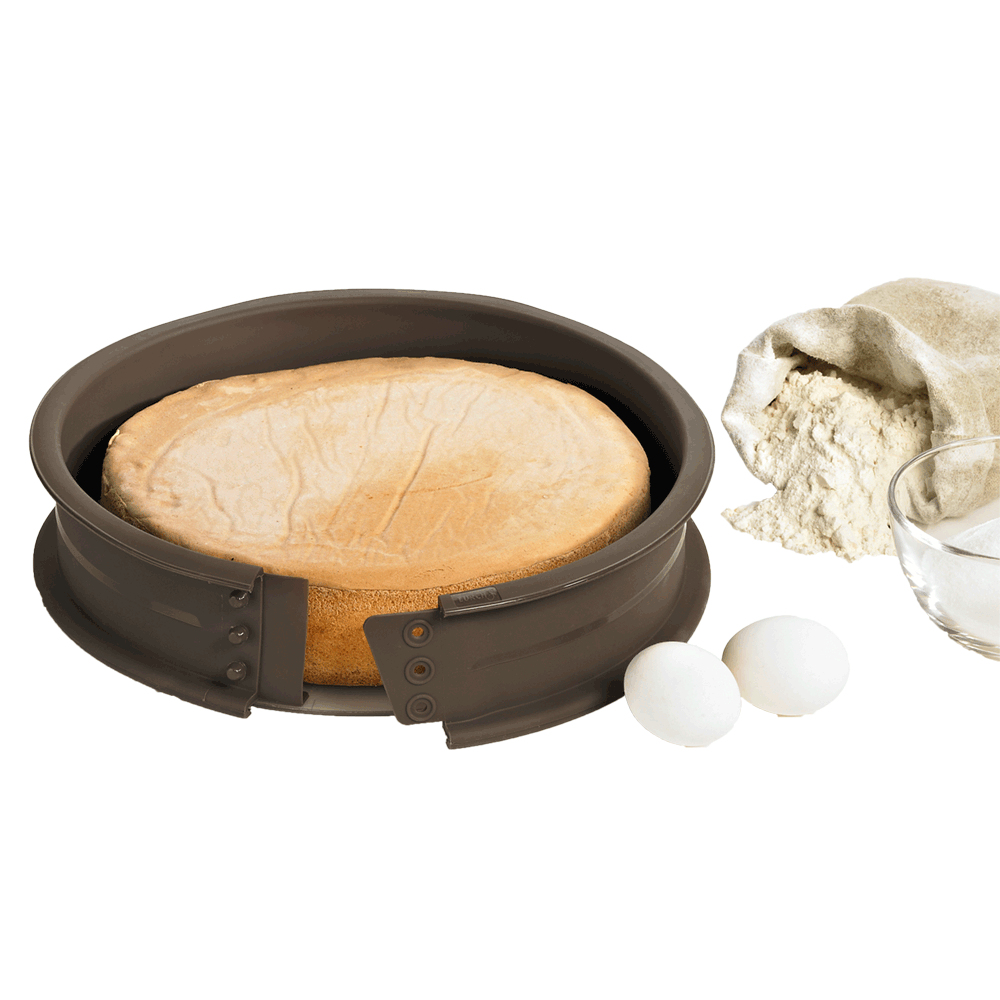 Ciasto w formie do pieczenia ze składnikami takimi jak mąka i jajka w pobliżu. Patelnia jest brązowa.
