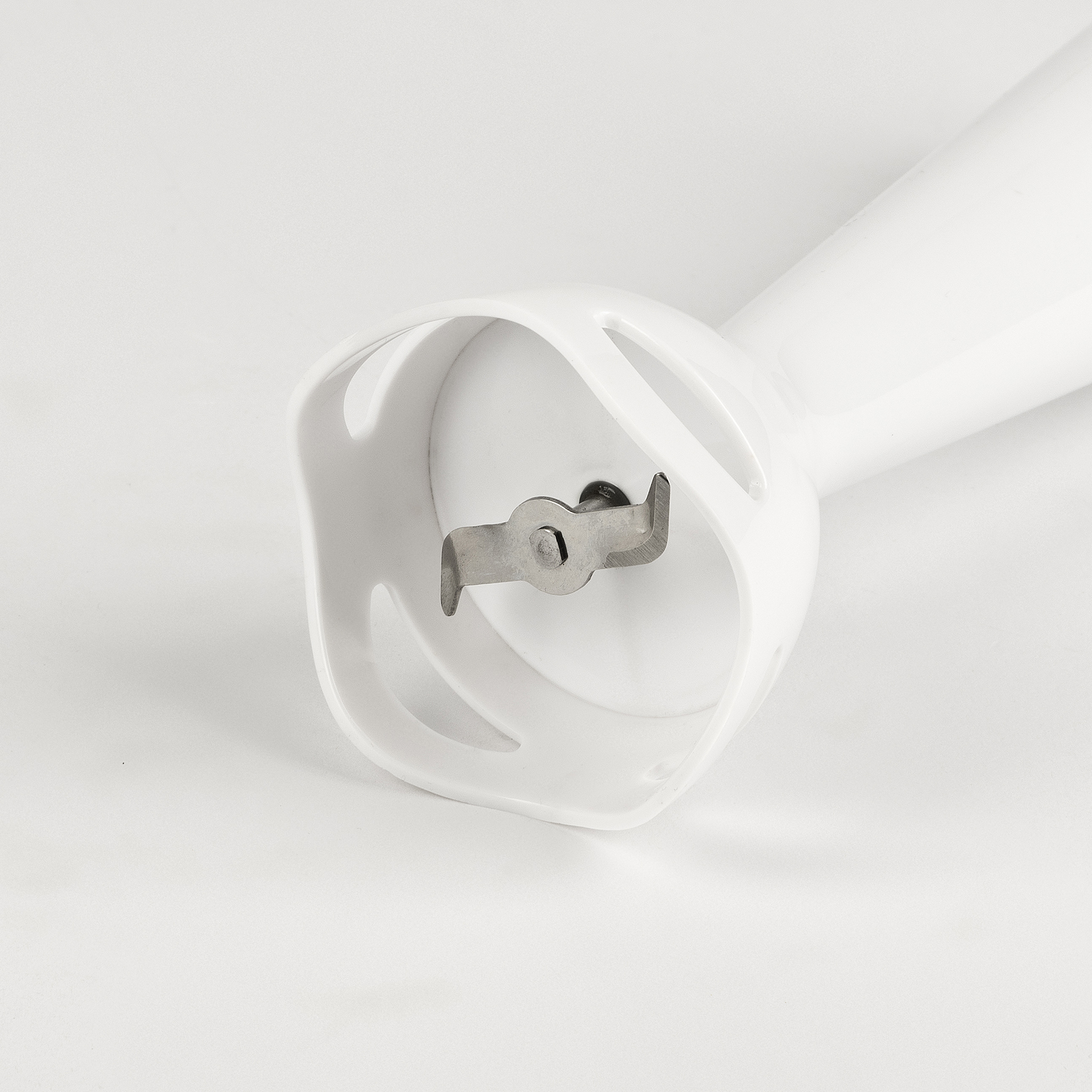 Zbliżenie białej końcówki blendera ręcznego z ostrzem.