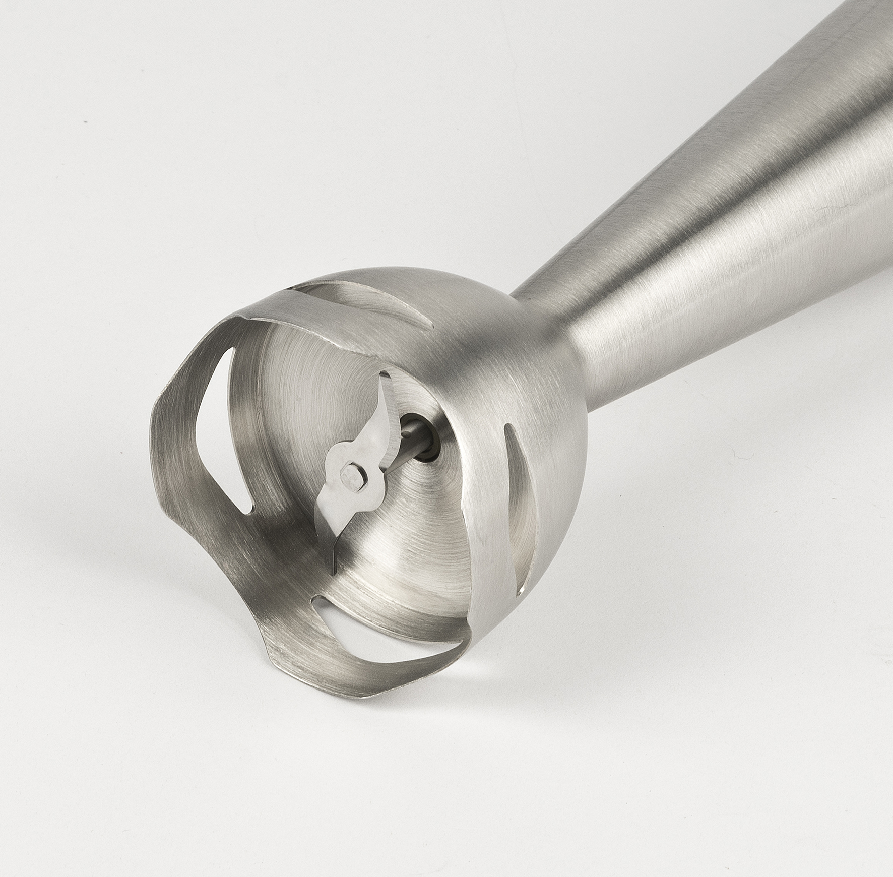 Zbliżenie srebrnej końcówki blendera ręcznego, z ostrzami i zakrzywioną obudową ochronną.