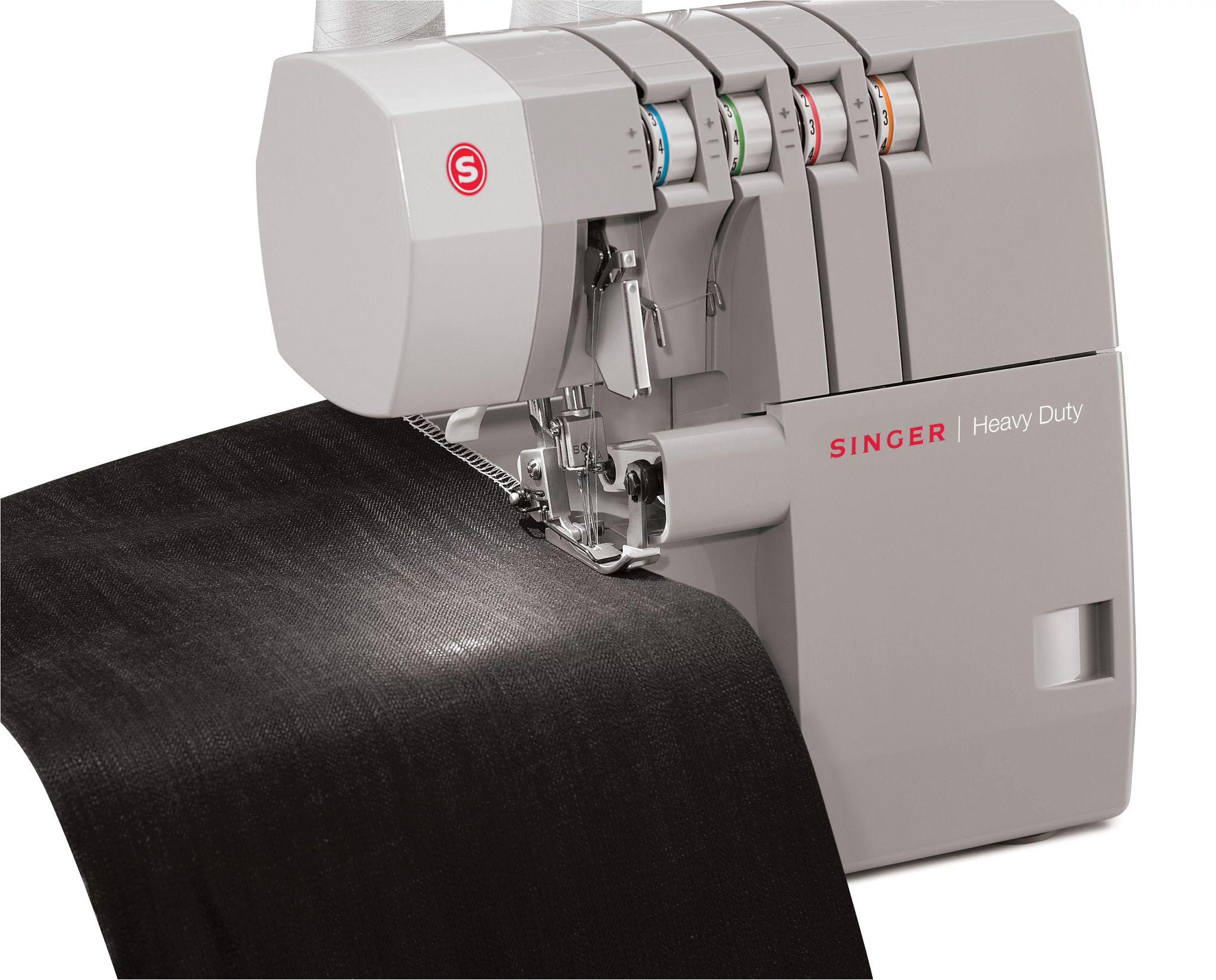 Eine Singer Heavy Duty Overlock-Nähmaschine, grau, näht schwarzen Stoff, auf weißem Hintergrund.