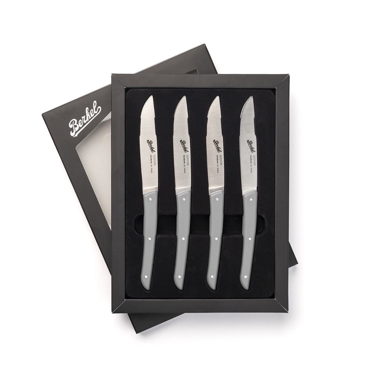 Set of four gray steak knives in a black box, with a white background.