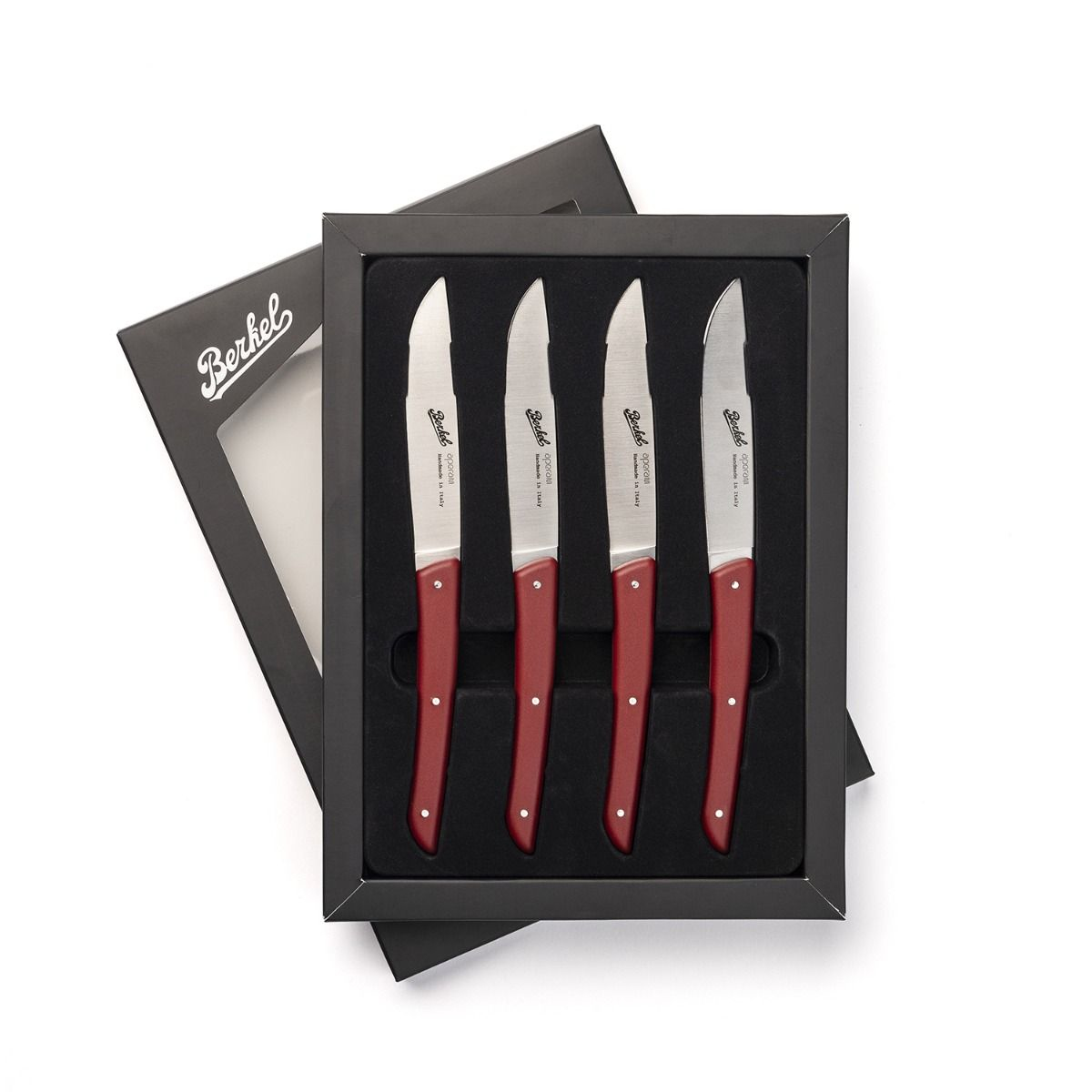 Four red-handled knives in a black box. Knives have silver blades. White background.