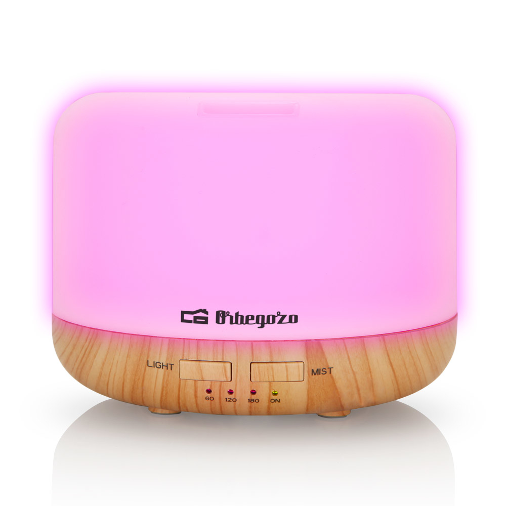 Dyfuzor zapachów świecący na różowo, z drewnianą podstawą i przyciskami. Biała powierzchnia.