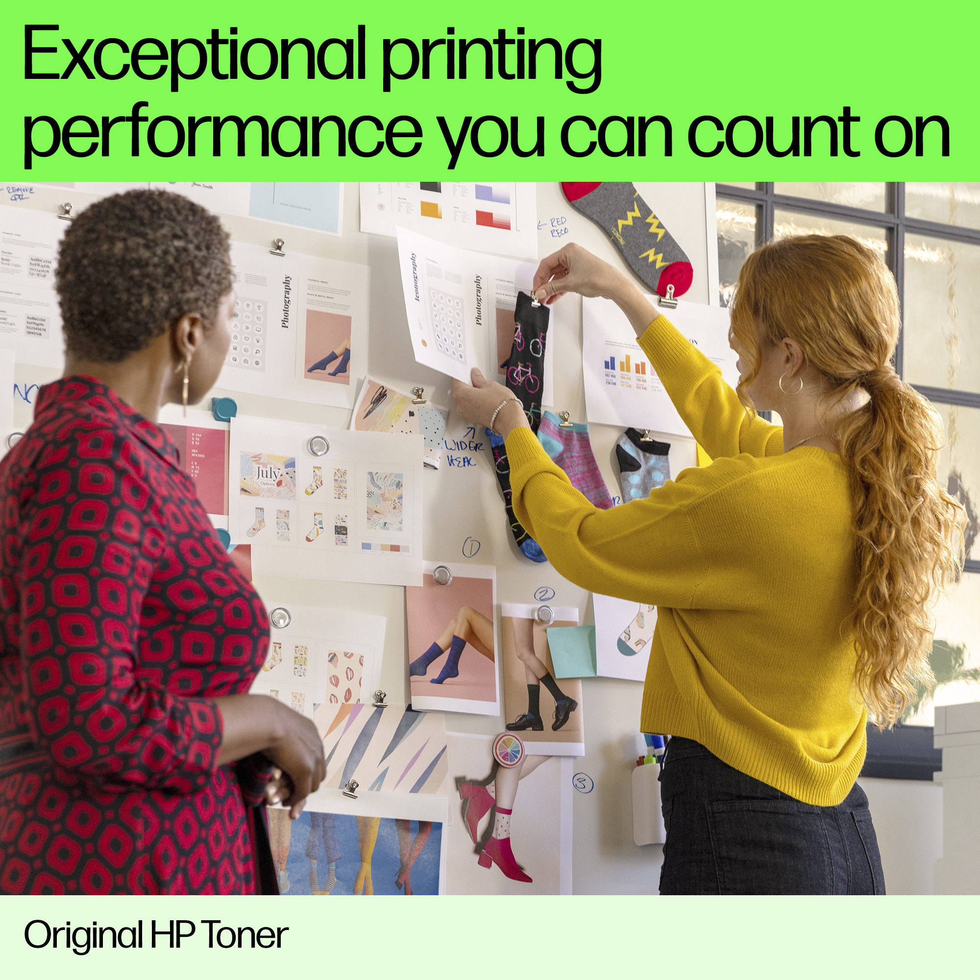 Dwie kobiety badają papiery na ścianie. Tekst brzmi: „Wyjątkowa wydajność drukowania, na której możesz polegać”.