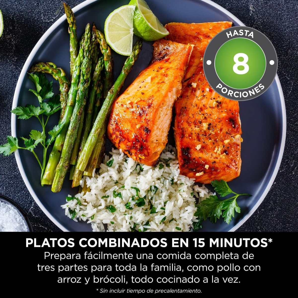 Un plato de comida con salmón, arroz, espárragos y rodajas de lima.