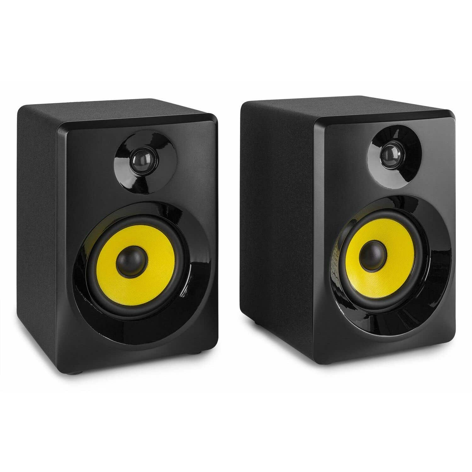 Dos altavoces de monitor de estudio negros con conos de altavoz amarillos. Los altavoces están uno al lado del otro.