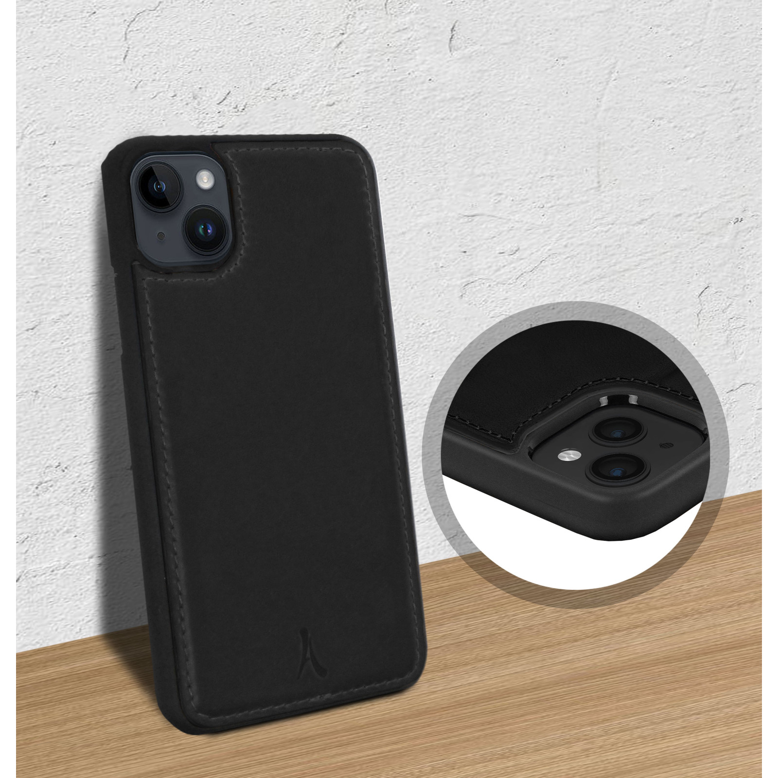 Custodia iPhone nera con porta carte, appoggiata a muro su legno.
