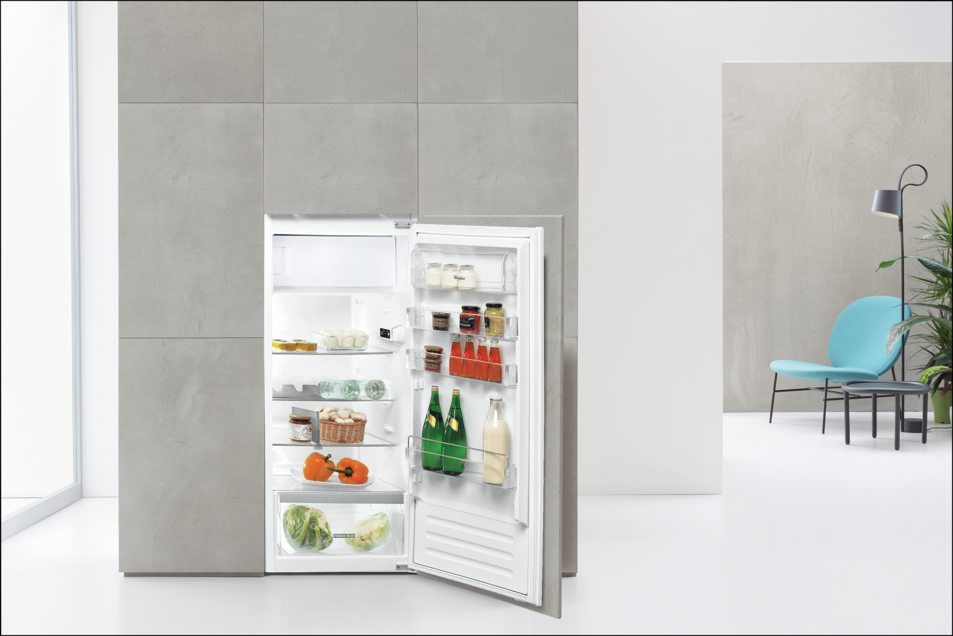 Un frigorifero con la porta aperta, pieno di cibo e bevande, in una cucina.