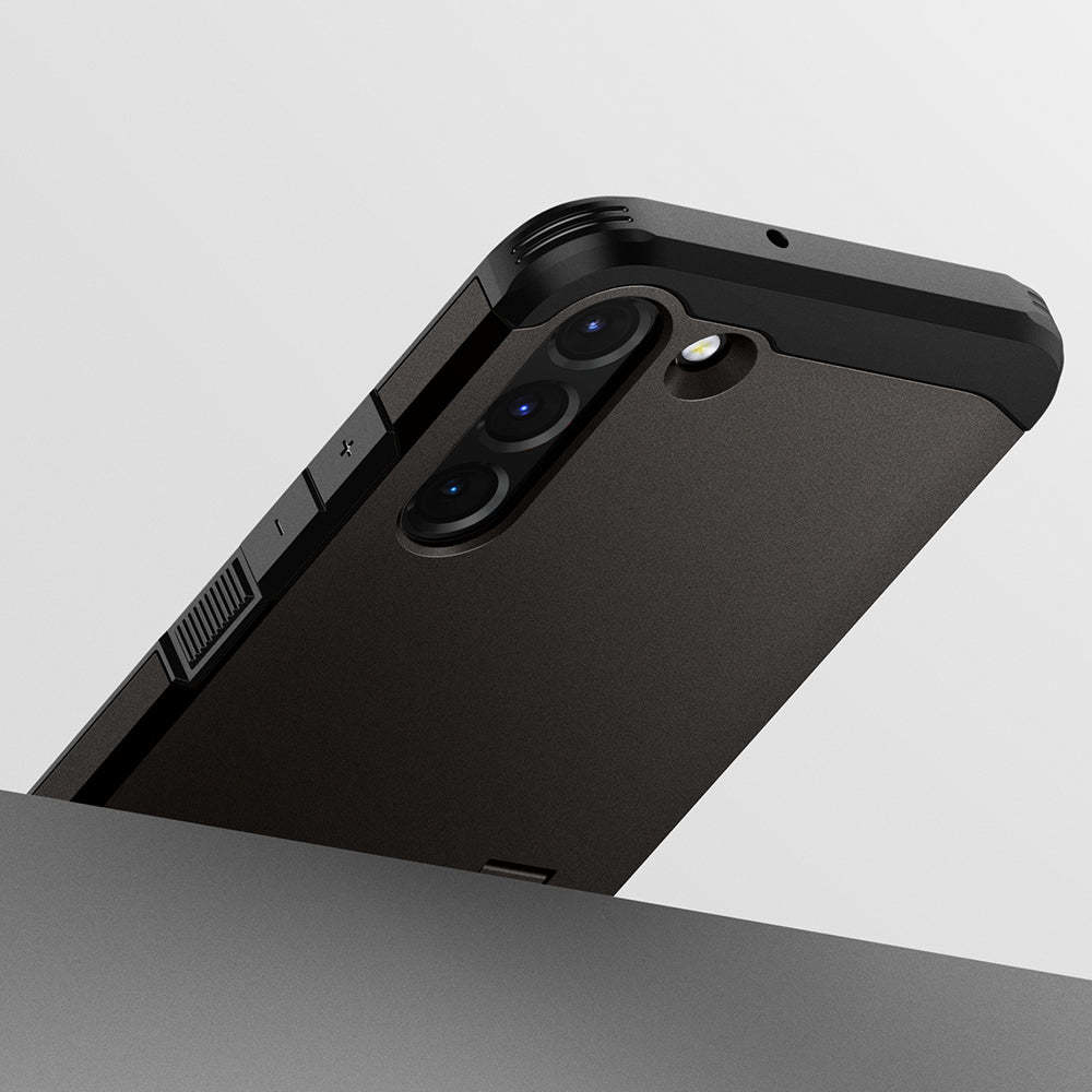 Telefono nero in una custodia nera leggermente angolato. La fotocamera è visibile. La custodia è su una superficie.