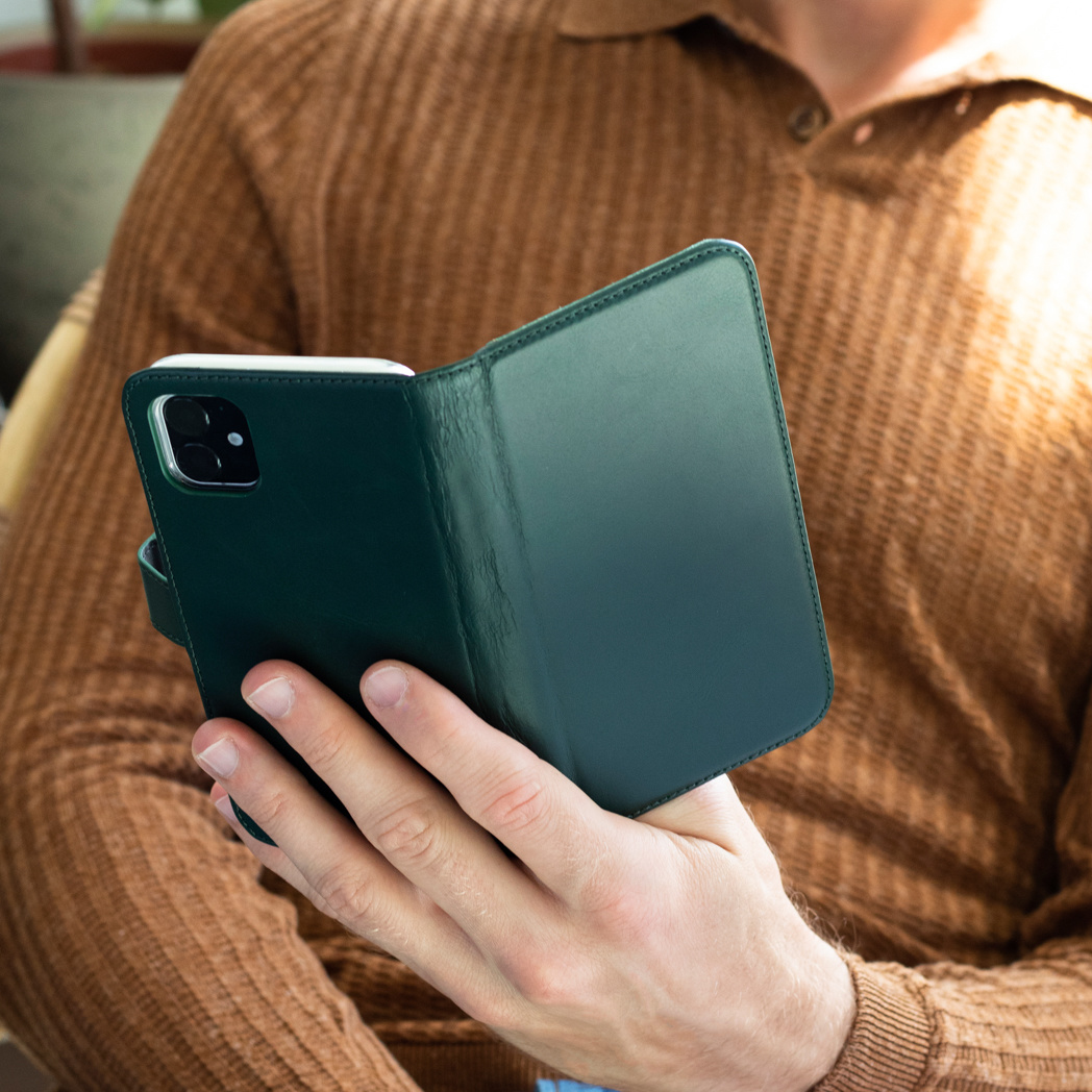 Un homme tient une coque de téléphone verte. La coque est ouverte, révélant le téléphone.