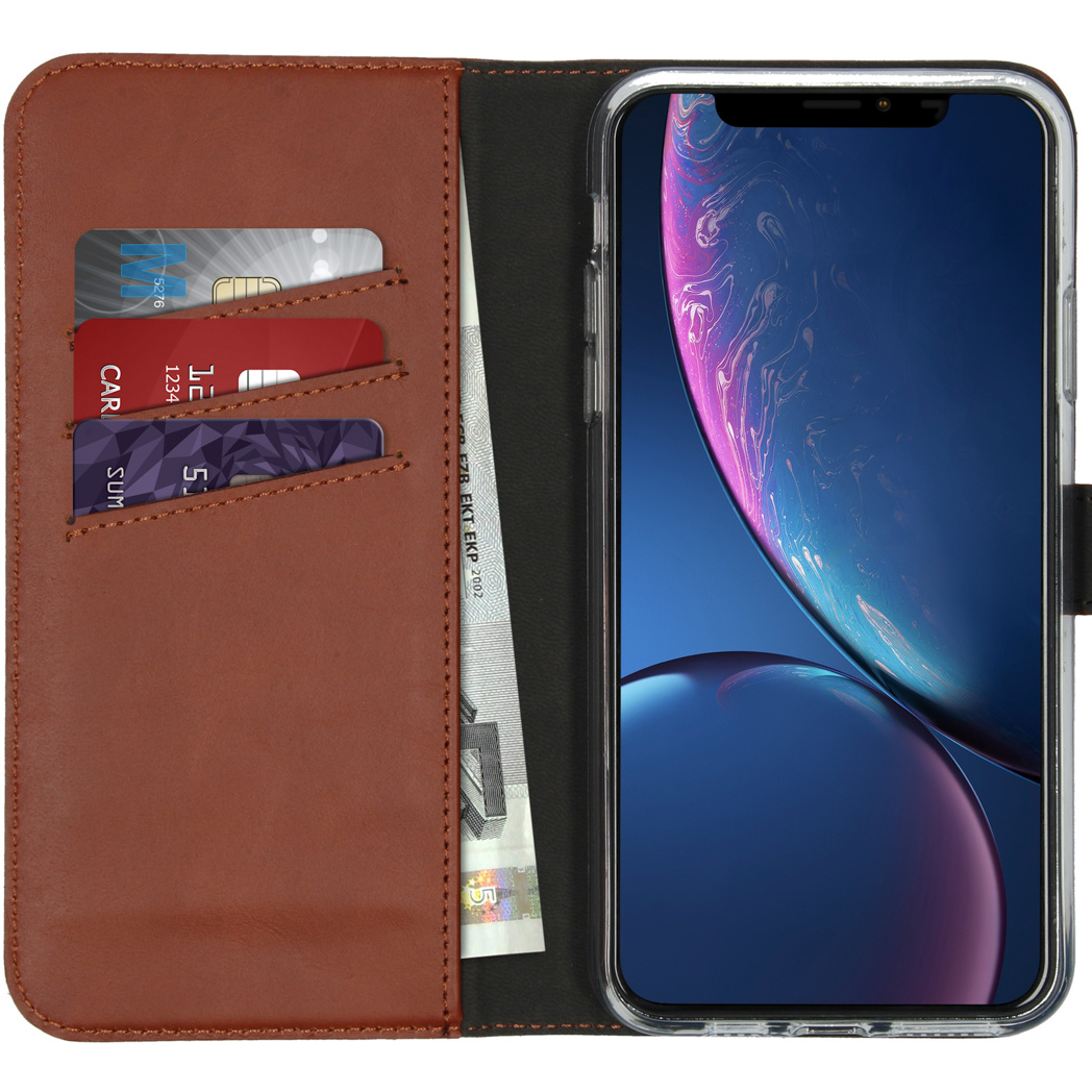 Téléphone dans un étui portefeuille en cuir marron. Cartes et billet visibles.