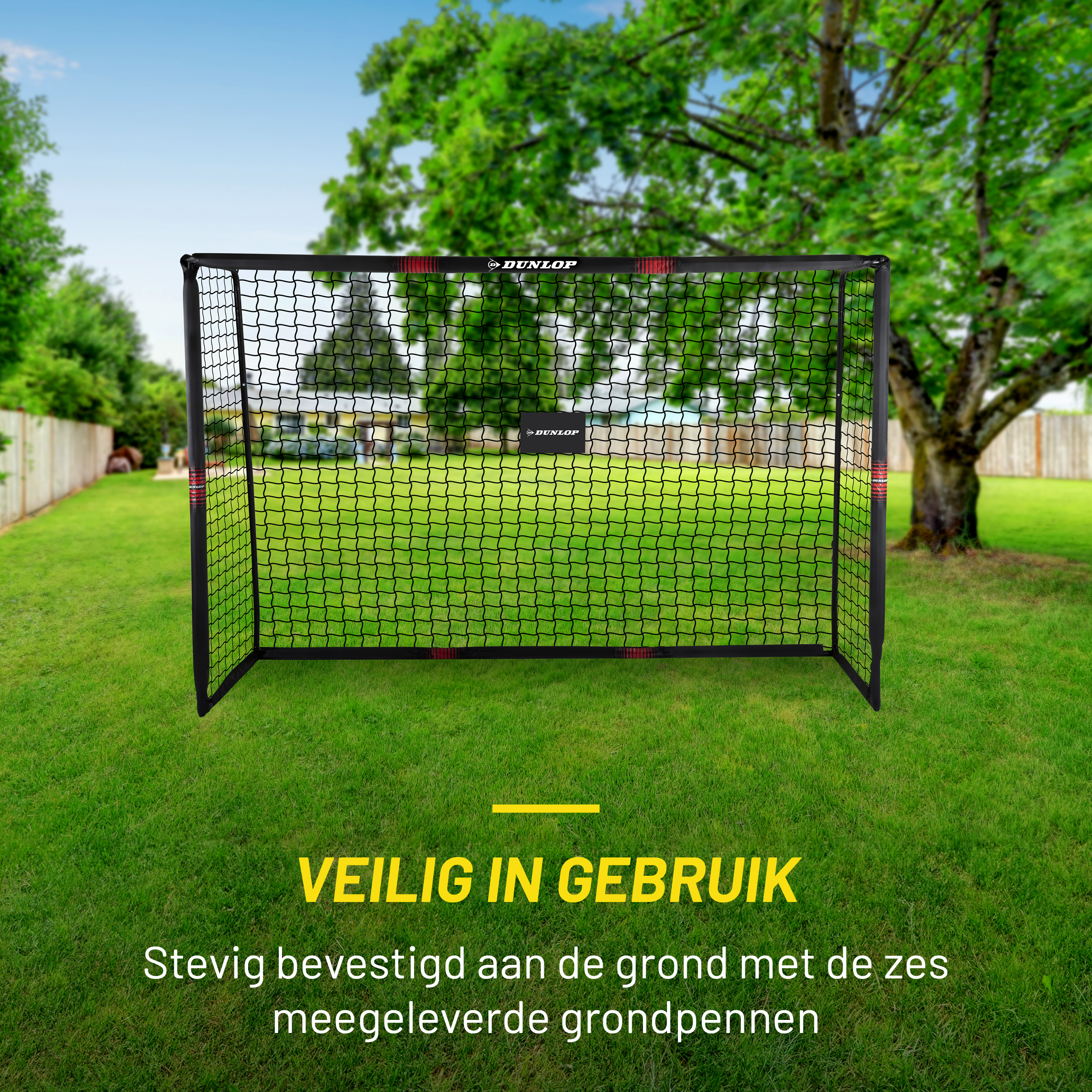 Soccer goal on grass. The goal is black. There is a label that says 'Dunlop'. The sky is blue.