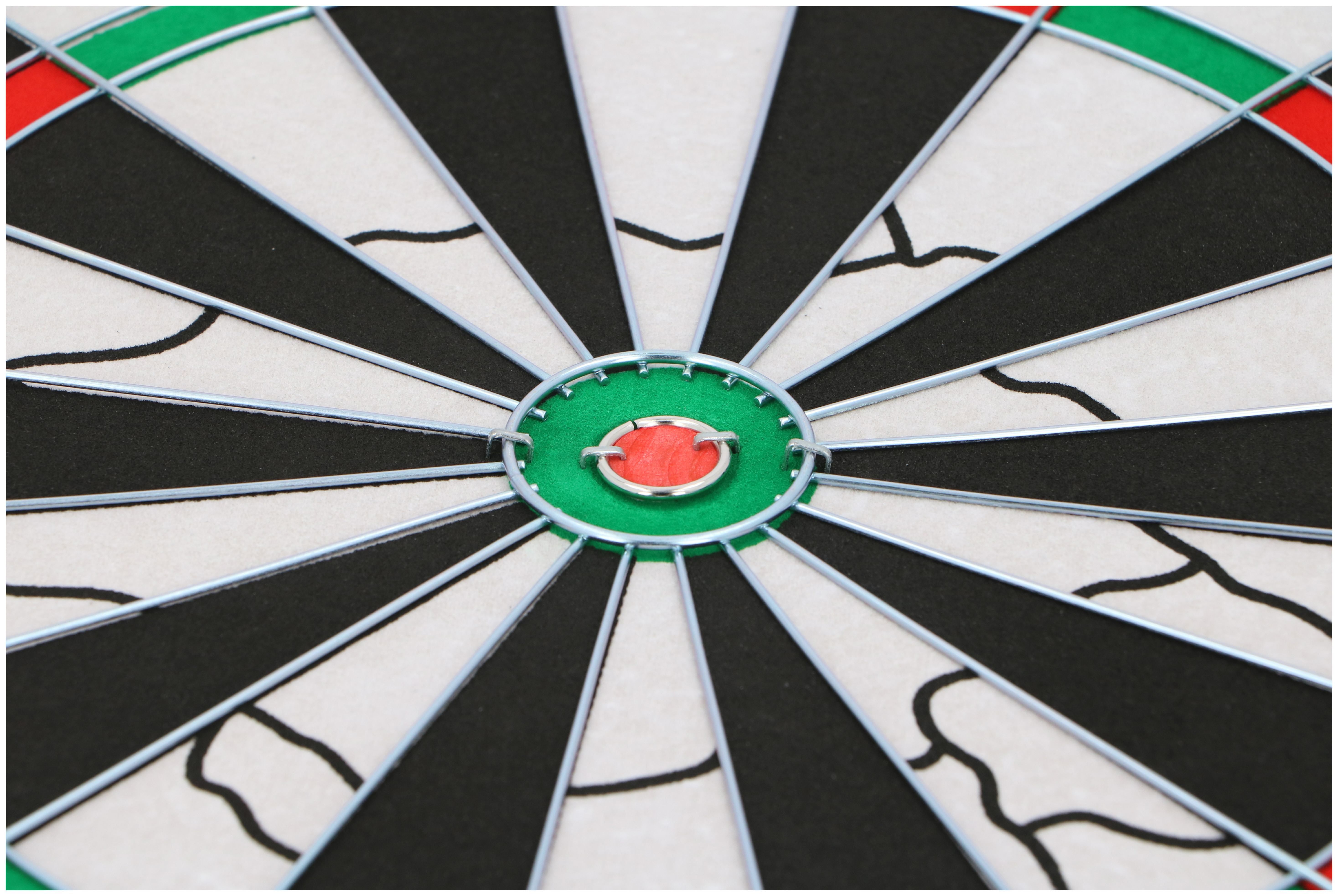 Close-up van een dartbord. Zwarte, witte en groene cirkels. Rood centrum. Zilveren draadframe.