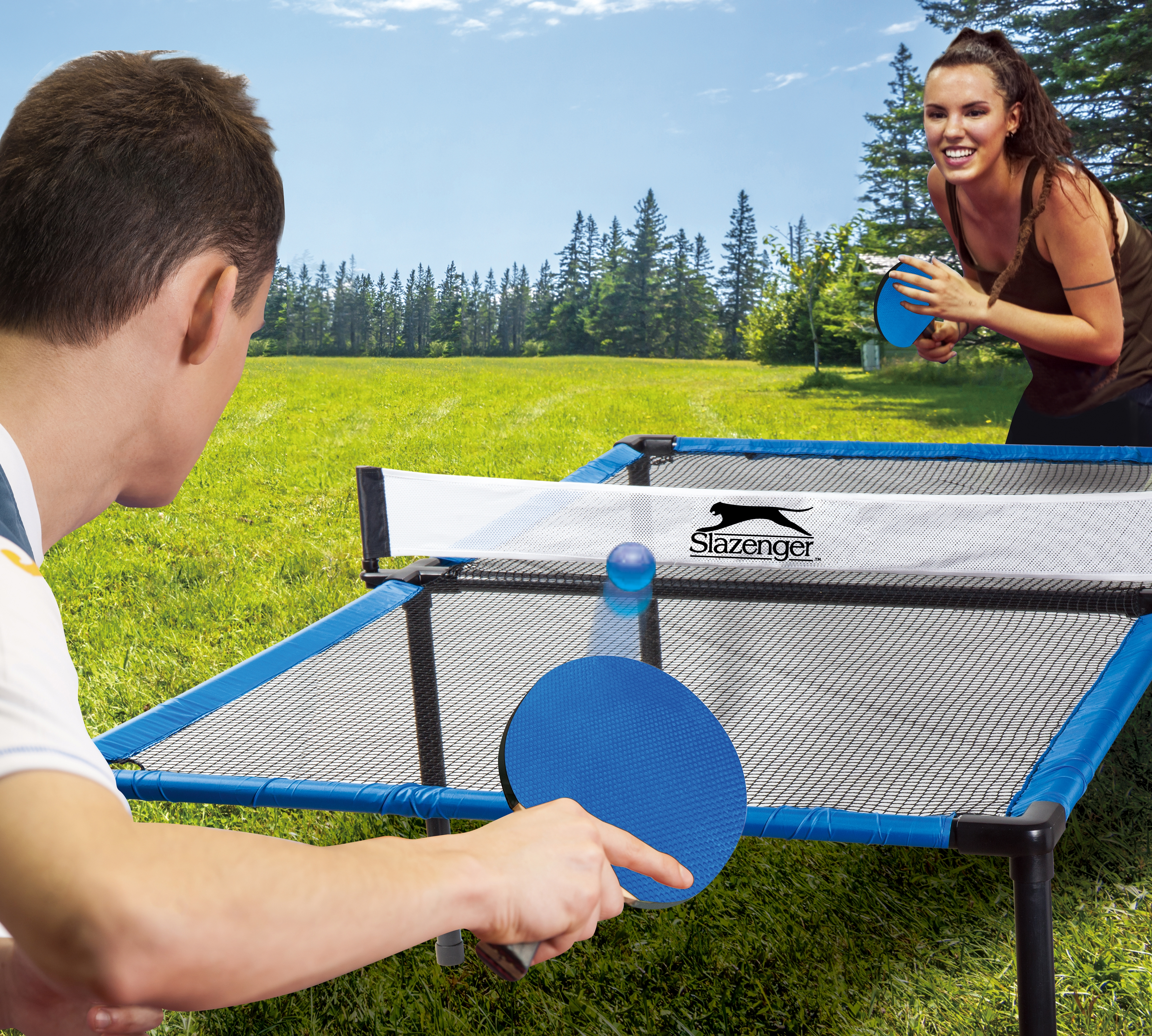 Een stel dat buiten tafeltennis speelt, met blauwe rackets en een bal.