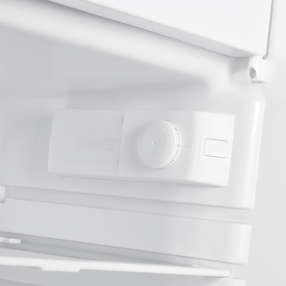 Białe wnętrze lodówki z pokrętłem i przyciskiem regulacji temperatury.