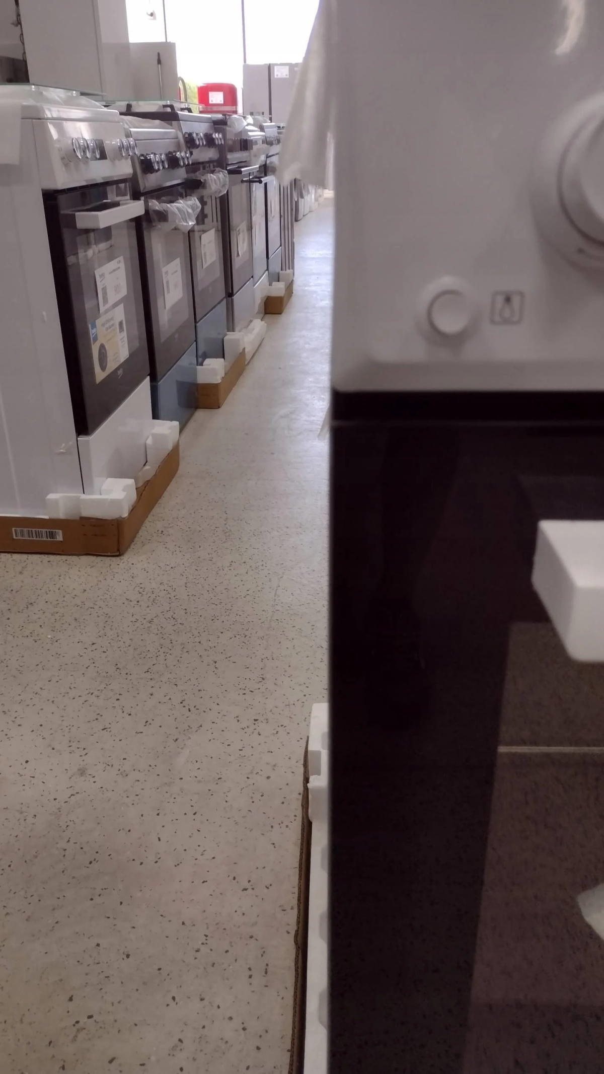Una fila de estufas blancas, vista lateral en una tienda.