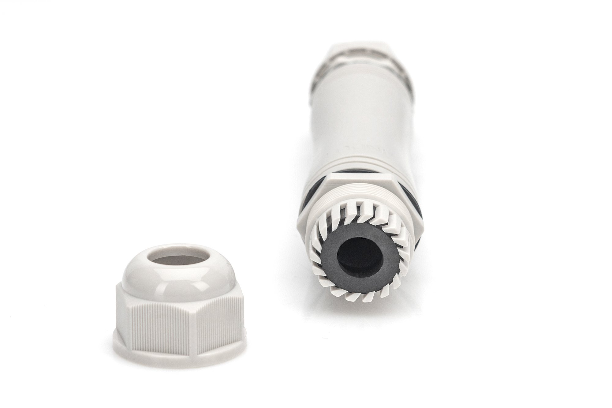 Szary, wodoodporny łącznik kablowy z odłączoną nasadką na białym tle.