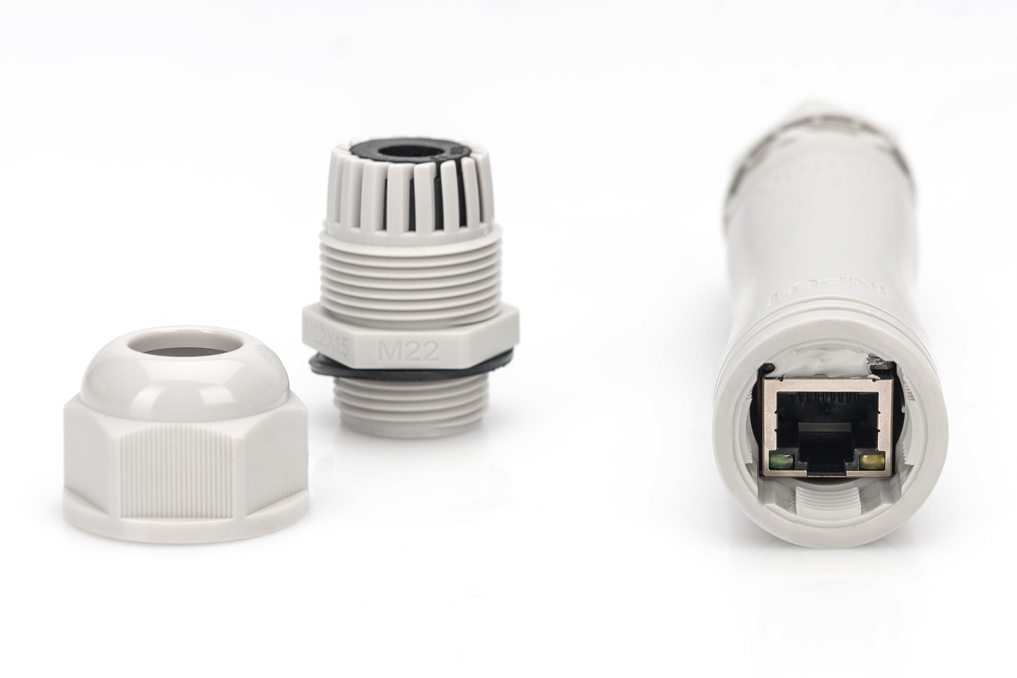 Szare części złącza kablowego; sekcja z portem RJ45 i nasadką.