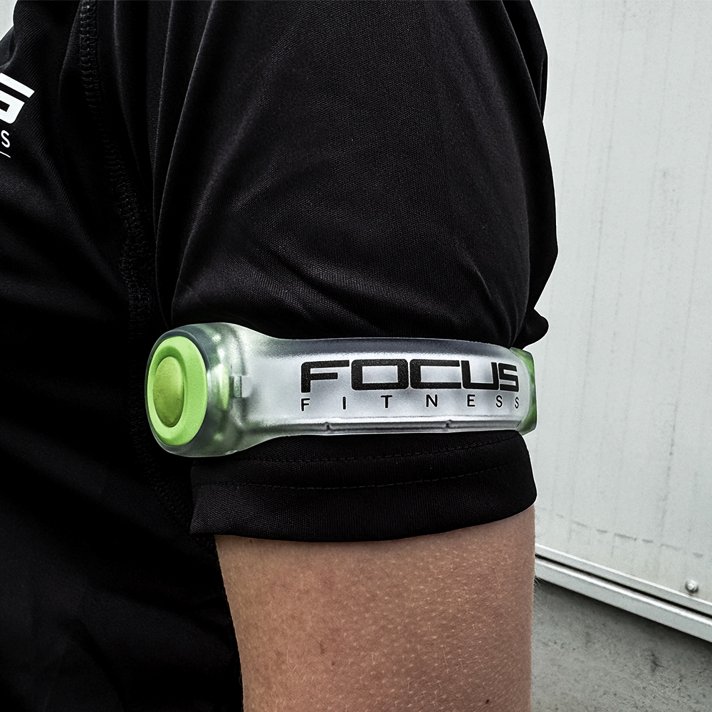 Een zwarte armband met een groene bevestiging en de tekst: FOCUS FITNESS.