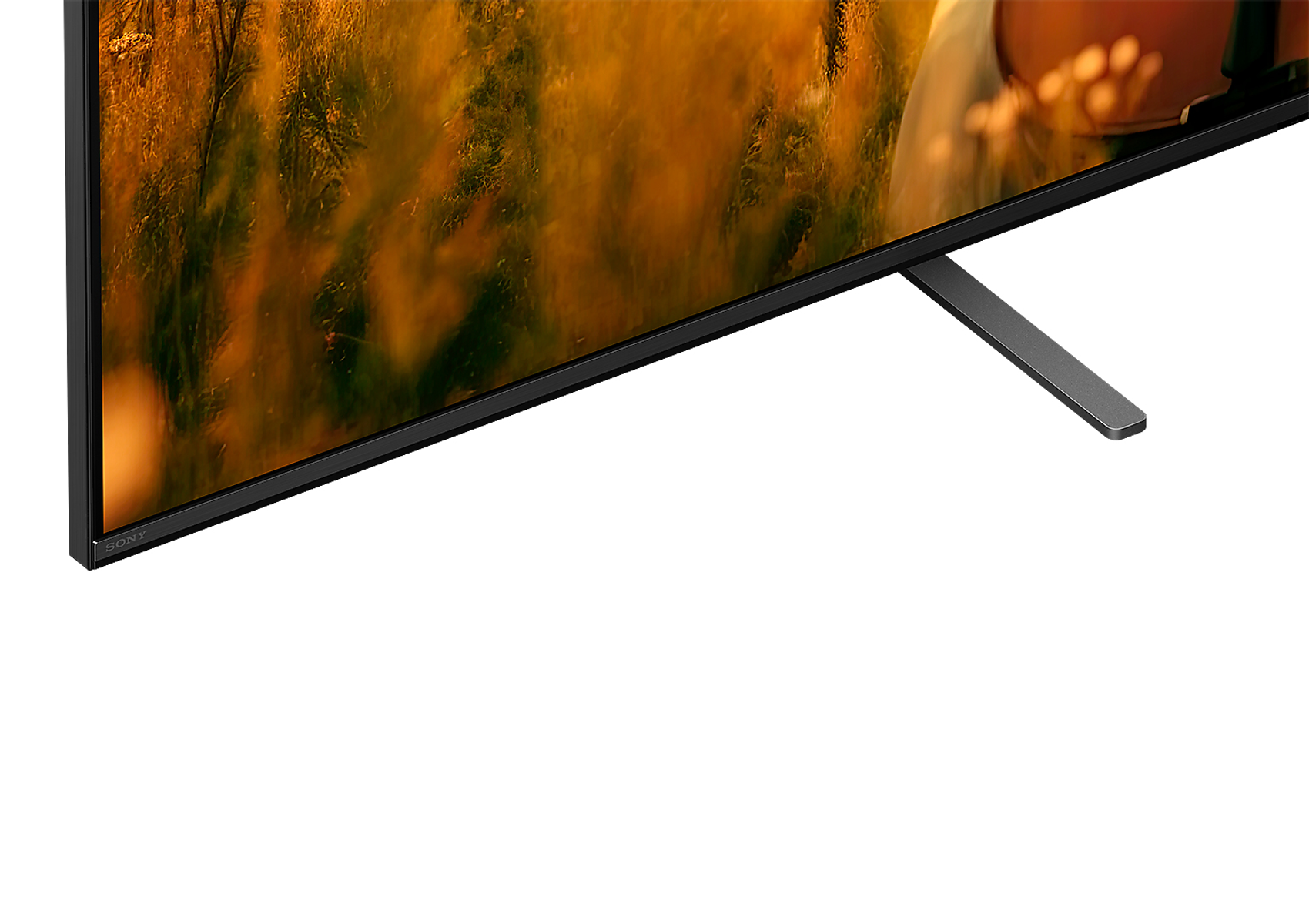 Nahaufnahme eines Sony TV-Sockels und Bildschirmrands. Weißer Hintergrund, warme Töne.