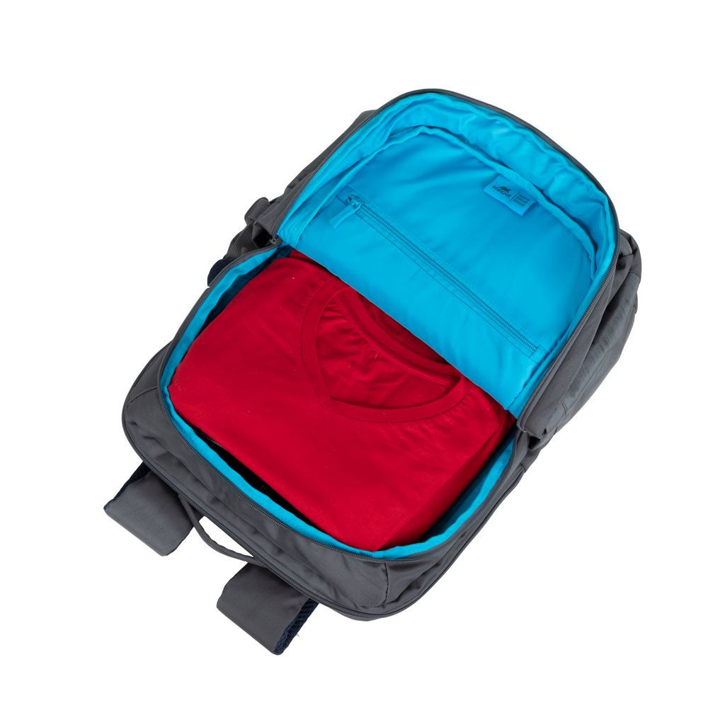 Grauer Rucksack, offen, mit rotem Hemd und blauer Innentasche. Weißer HG.