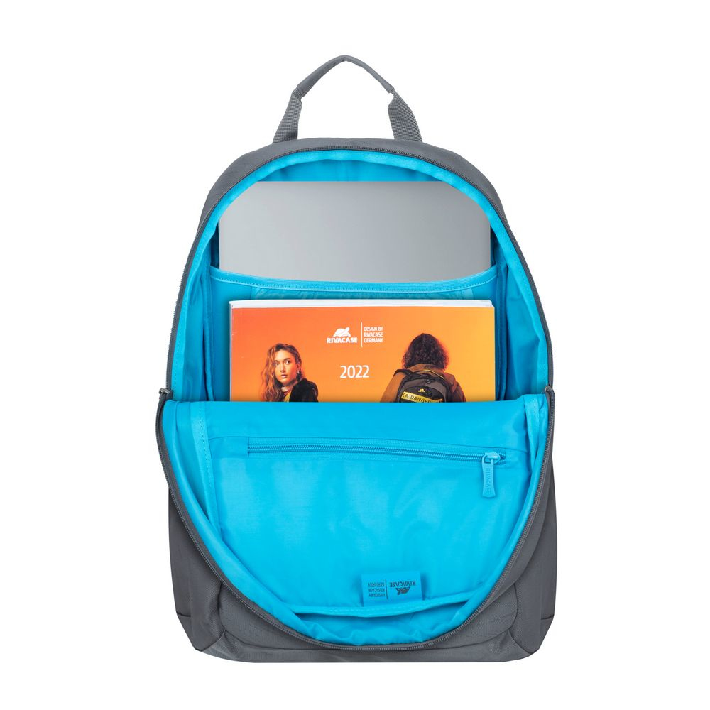 Ein grauer Rucksack geöffnet. Im Inneren sind ein Laptop, ein Buch und ein blaues Innere sichtbar.