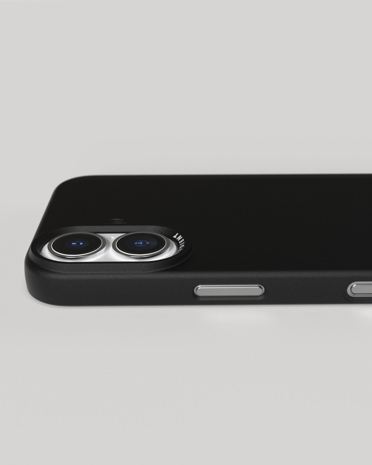 Coque de téléphone noire avec lentilles d'appareil photo, sur surface blanche, vue en angle.