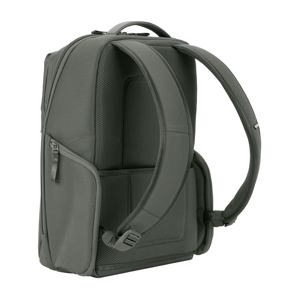 Grauer Rucksack mit gepolsterten Trägern. Seitliche Reißverschlusstasche sichtbar. Weißer Hintergrund.
