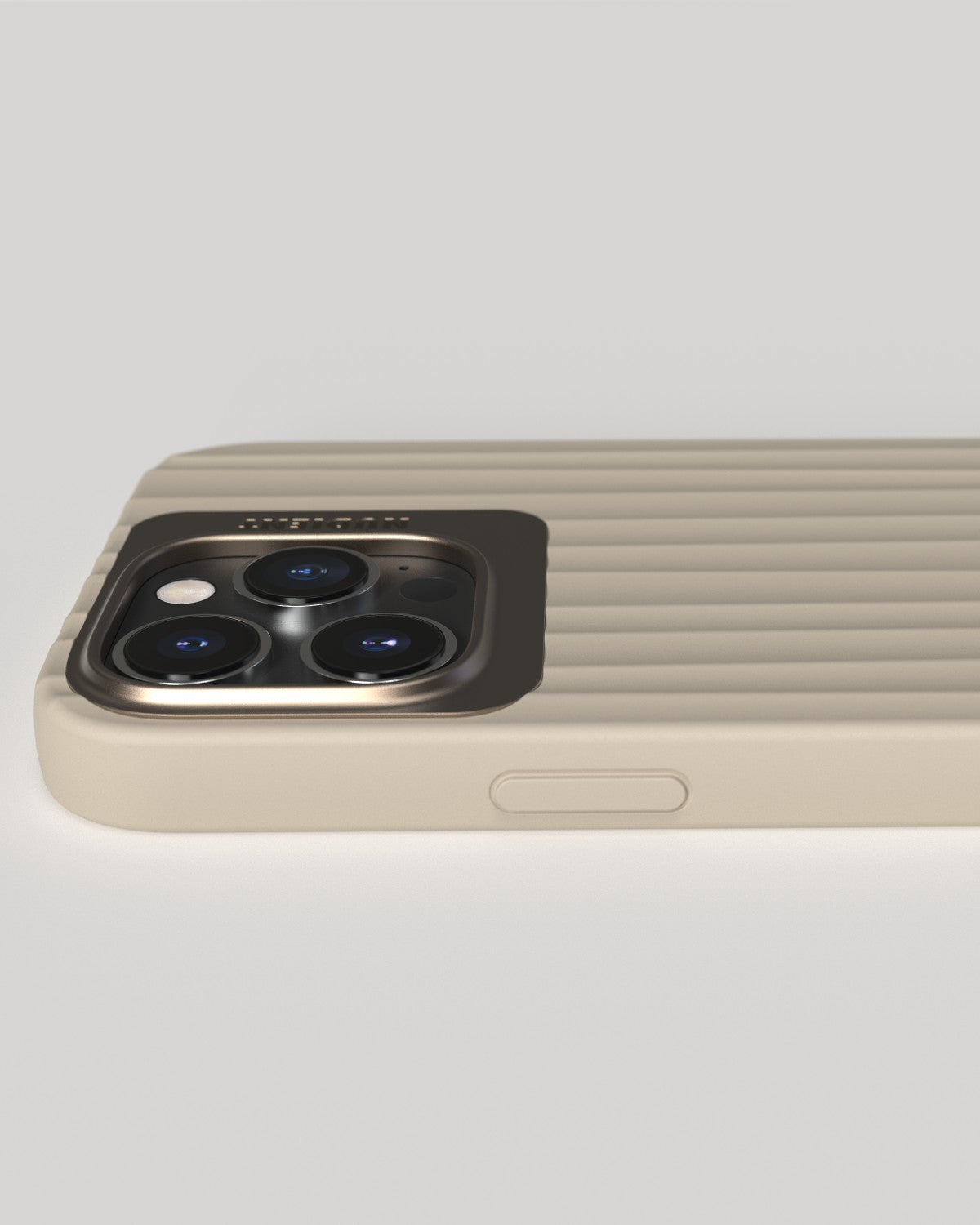 Gros plan de la coque de téléphone, beige, avec cadre métallique pour la caméra. Lignes verticales.