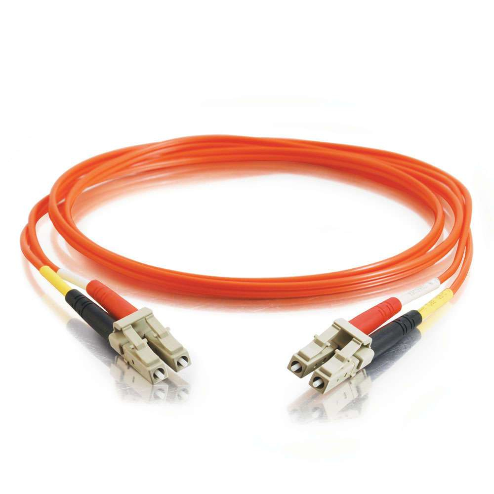 Cable de fibra óptica naranja con conectores, enrollado, sobre superficie blanca reflectante.