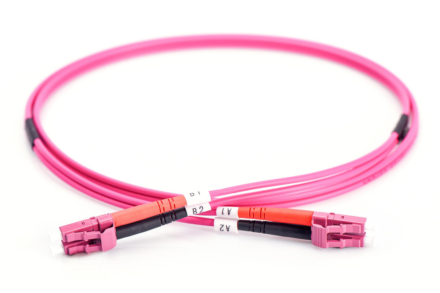 Câble fibre optique rose avec connecteurs sur fond blanc.