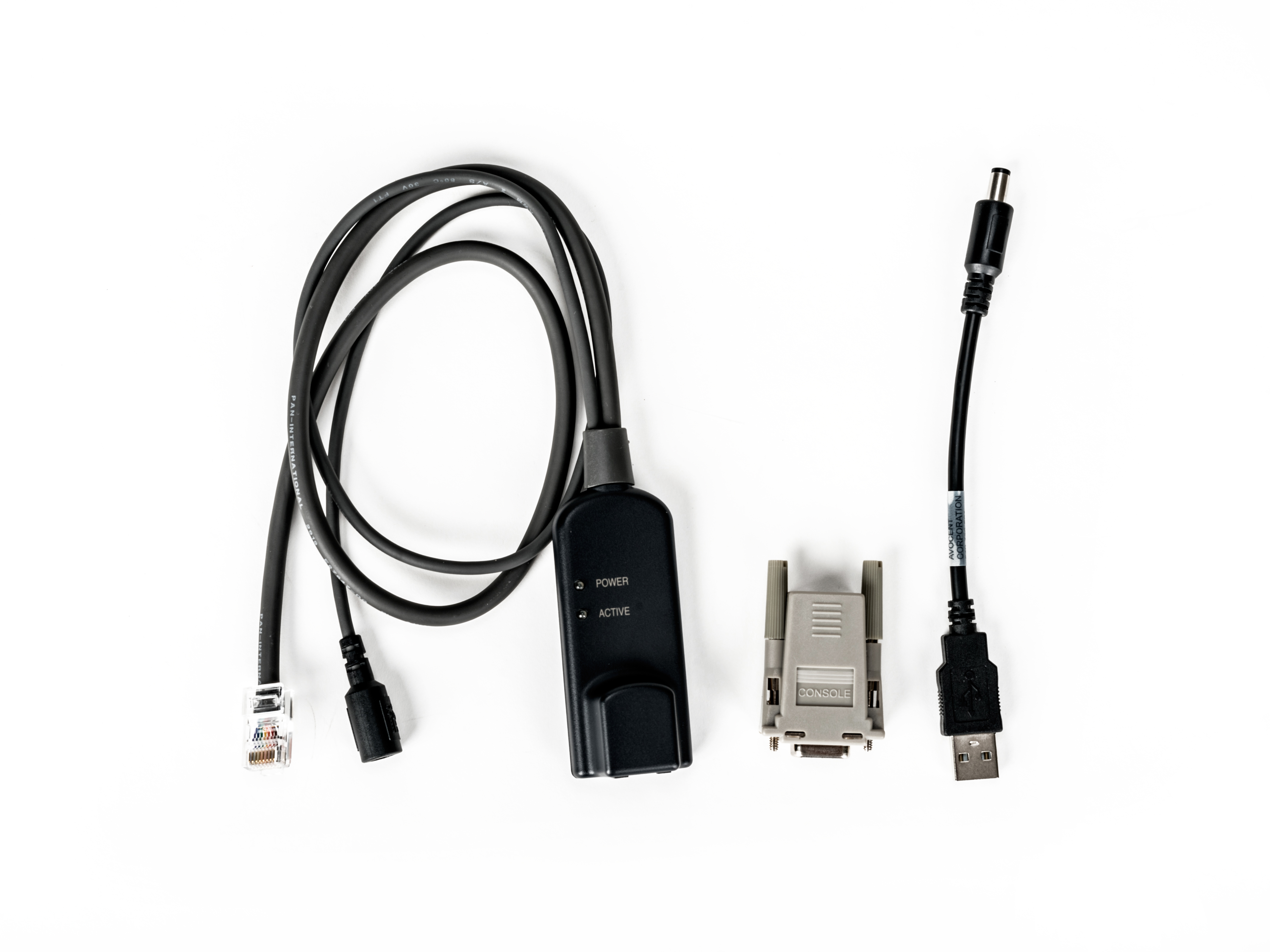Vari cavi e connettori su sfondo bianco. Include un connettore di alimentazione, una porta console e un cavo USB.