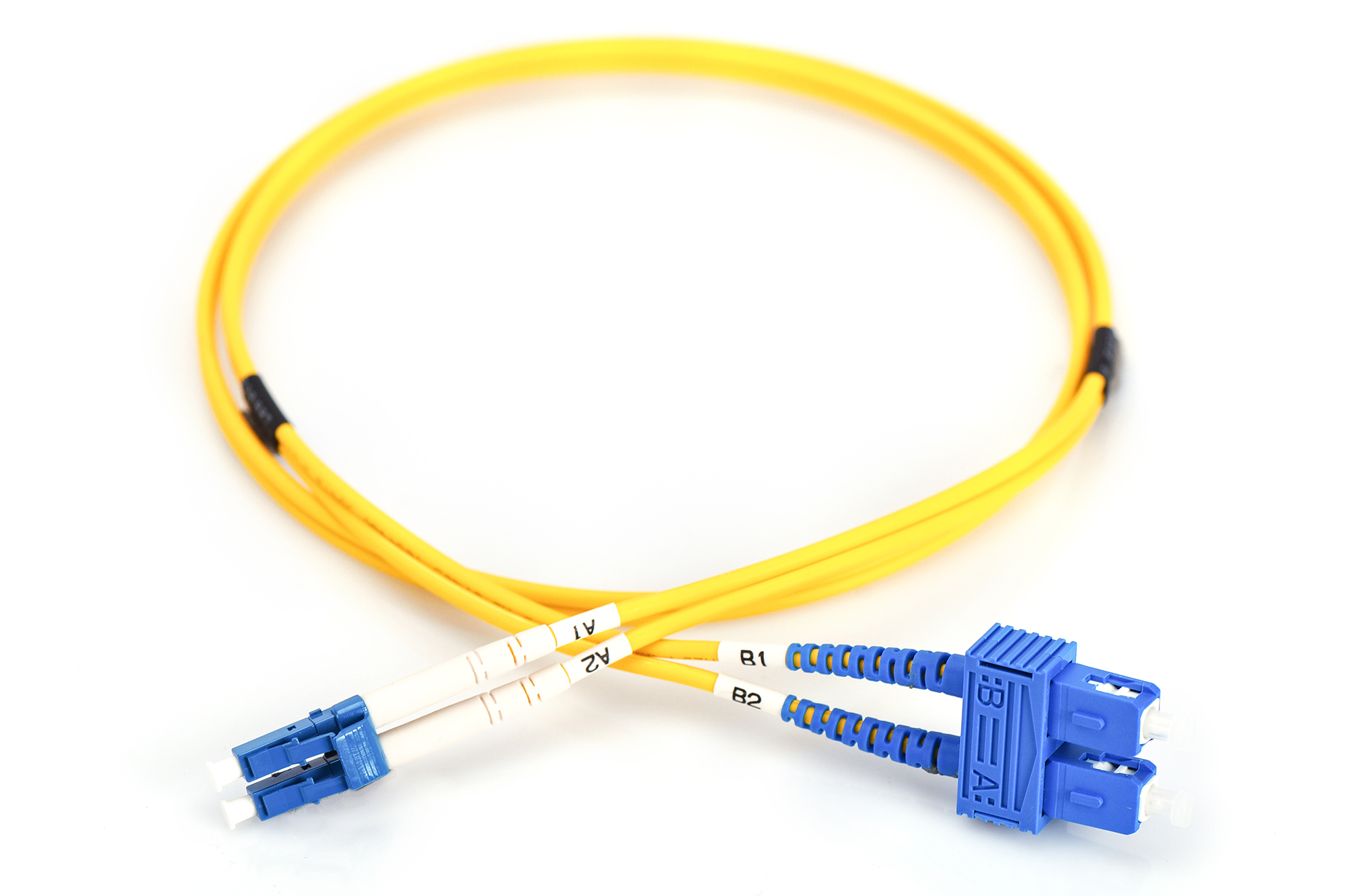 Cavo in fibra ottica giallo con connettori blu etichettati A1-A2 e B1-B2, arrotolato, bianco.