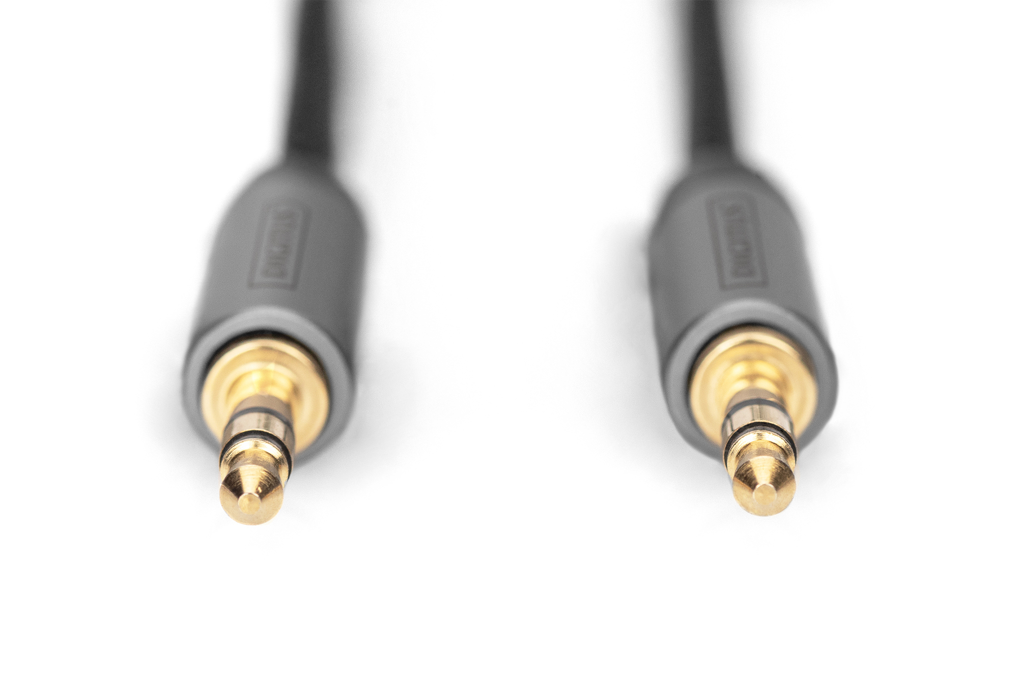 Gros plan sur deux fiches dorées 3,5 mm sur câble noir, fond blanc.