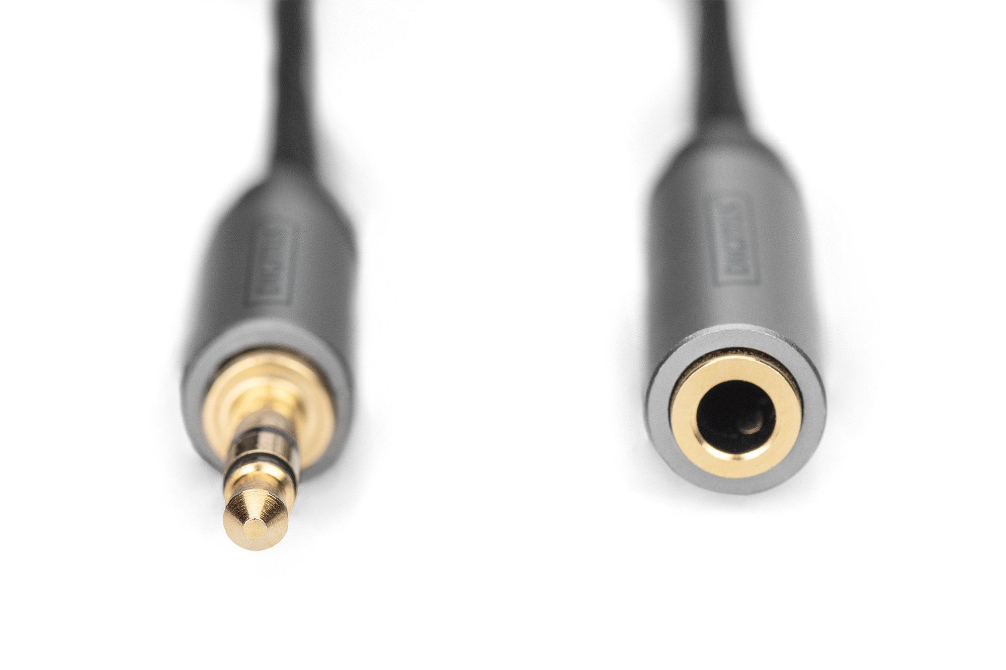 Cavo audio da 3,5 mm maschio a femmina. Punta dorata, corpo grigio, sfondo bianco.