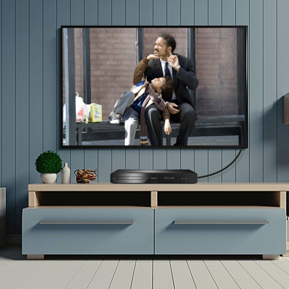 Un lettore DVD su un mobile con una scena di film in TV. Una pianta decora il mobile.