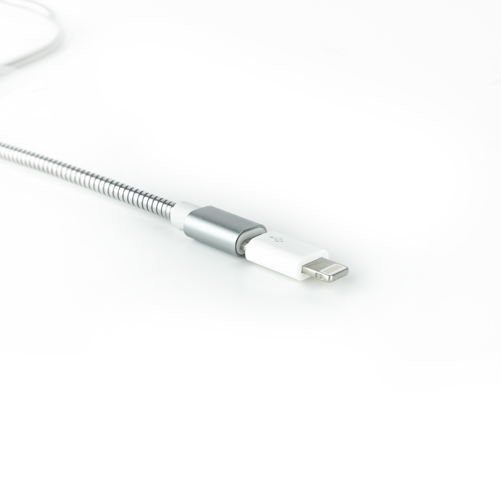 Un cavo di ricarica per telefono argento e bianco su sfondo bianco.