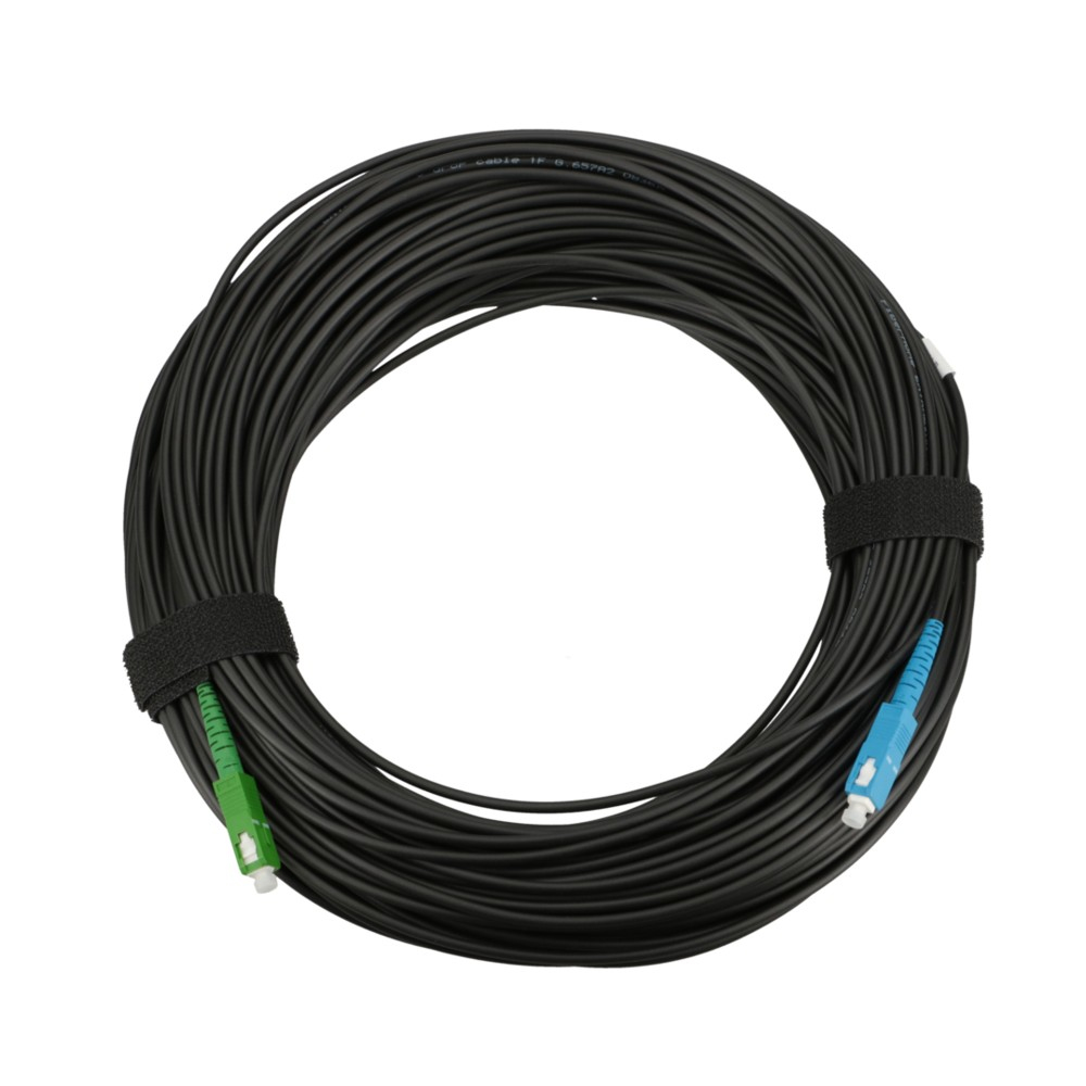Cavo nero arrotolato, con connettori verdi e blu. Fissato con cinturino in velcro nero. Sfondo bianco.