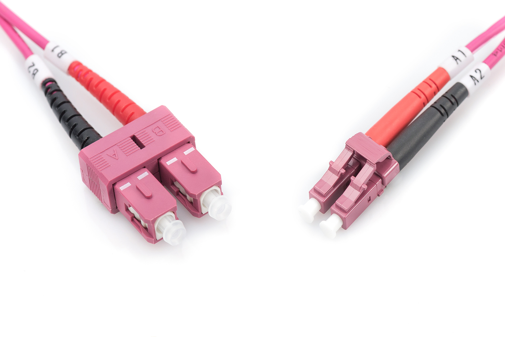 Cavi in fibra ottica rosa con connettori su sfondo bianco.