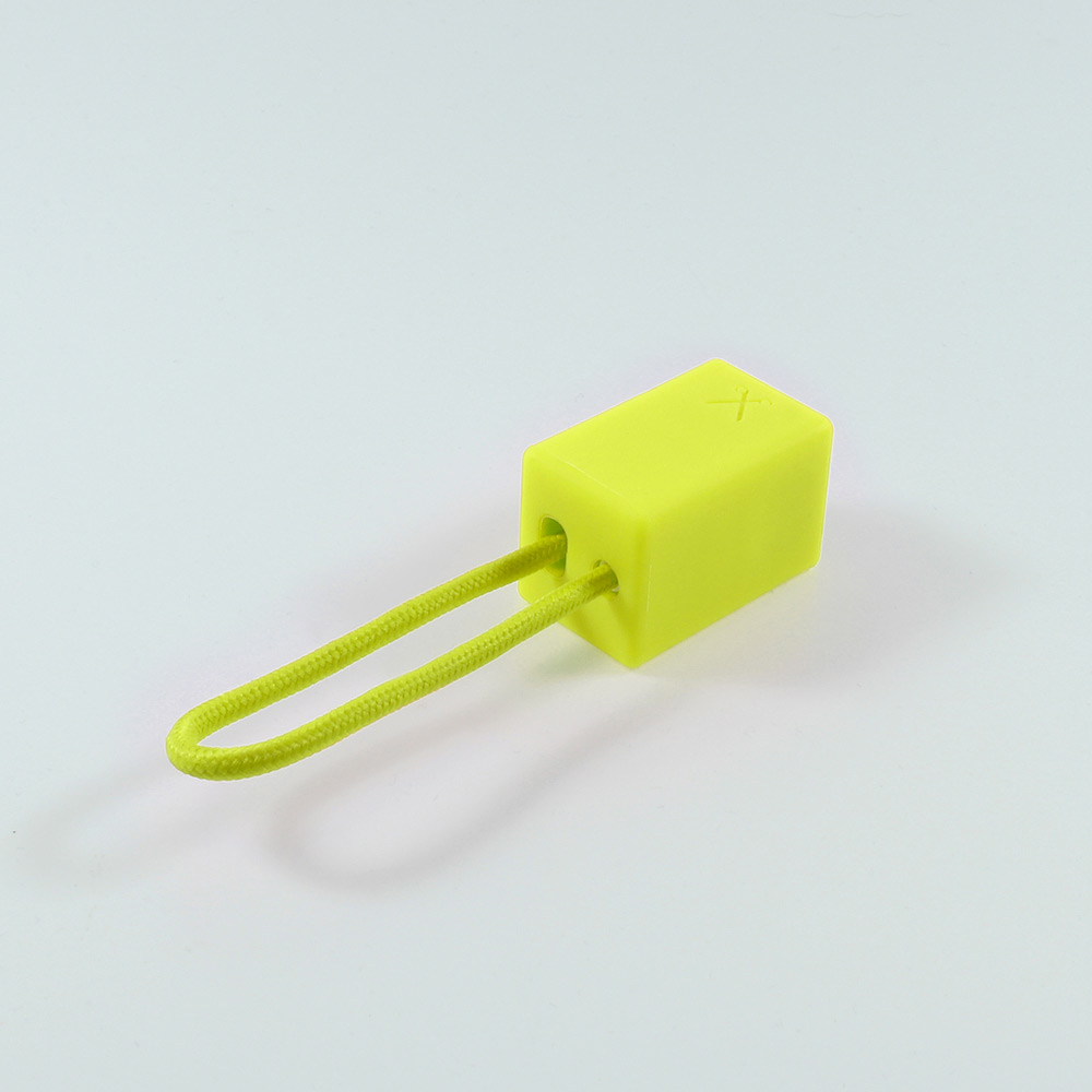 Oggetto rettangolare giallo con cordino verde su sfondo bianco.