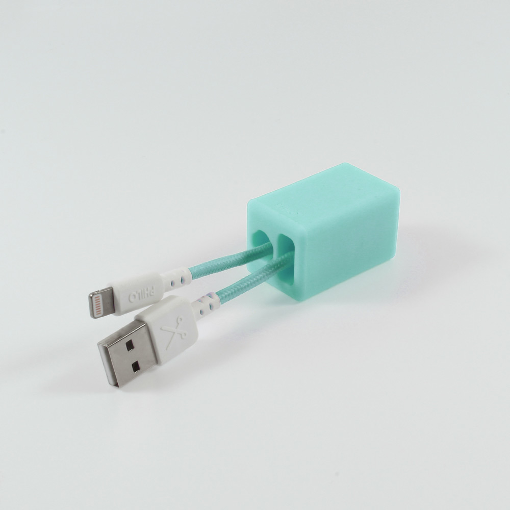 Un blocco turchese con un cavo USB e un lightning su sfondo bianco.